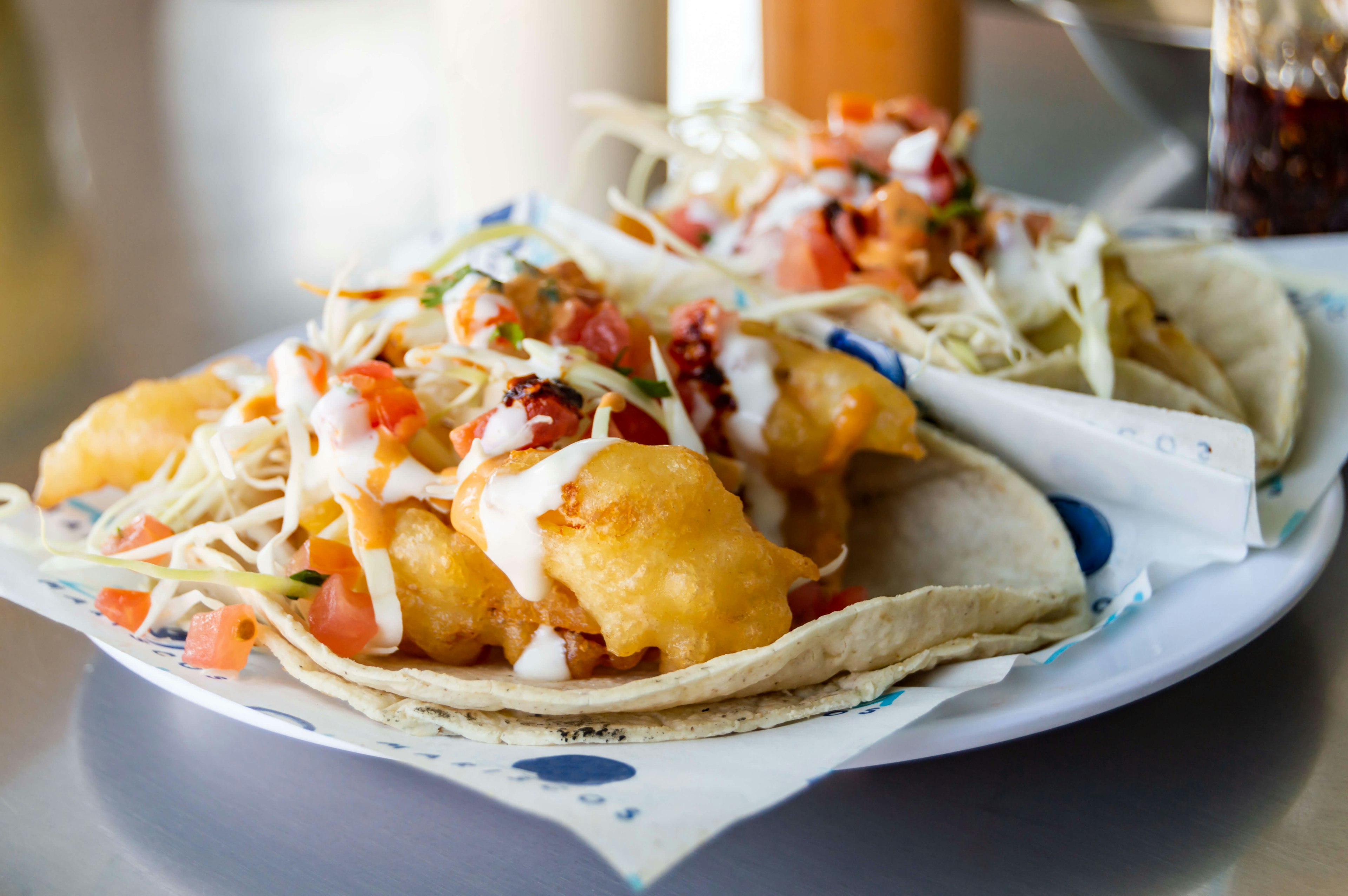 Baja California style fish and shrimp tacos, topped with cabbage, tomatoes, cilantro and a variety of salsas