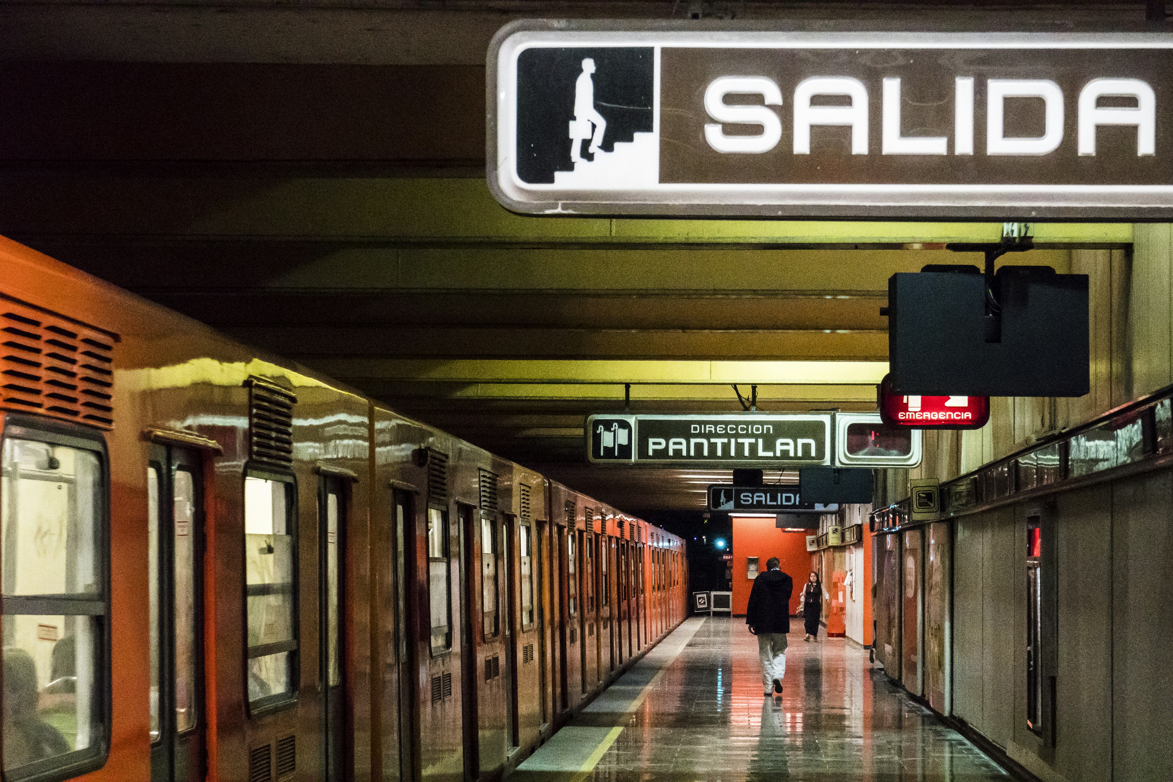 A platform of the Mexico City metro with a train waiting to depart next to it