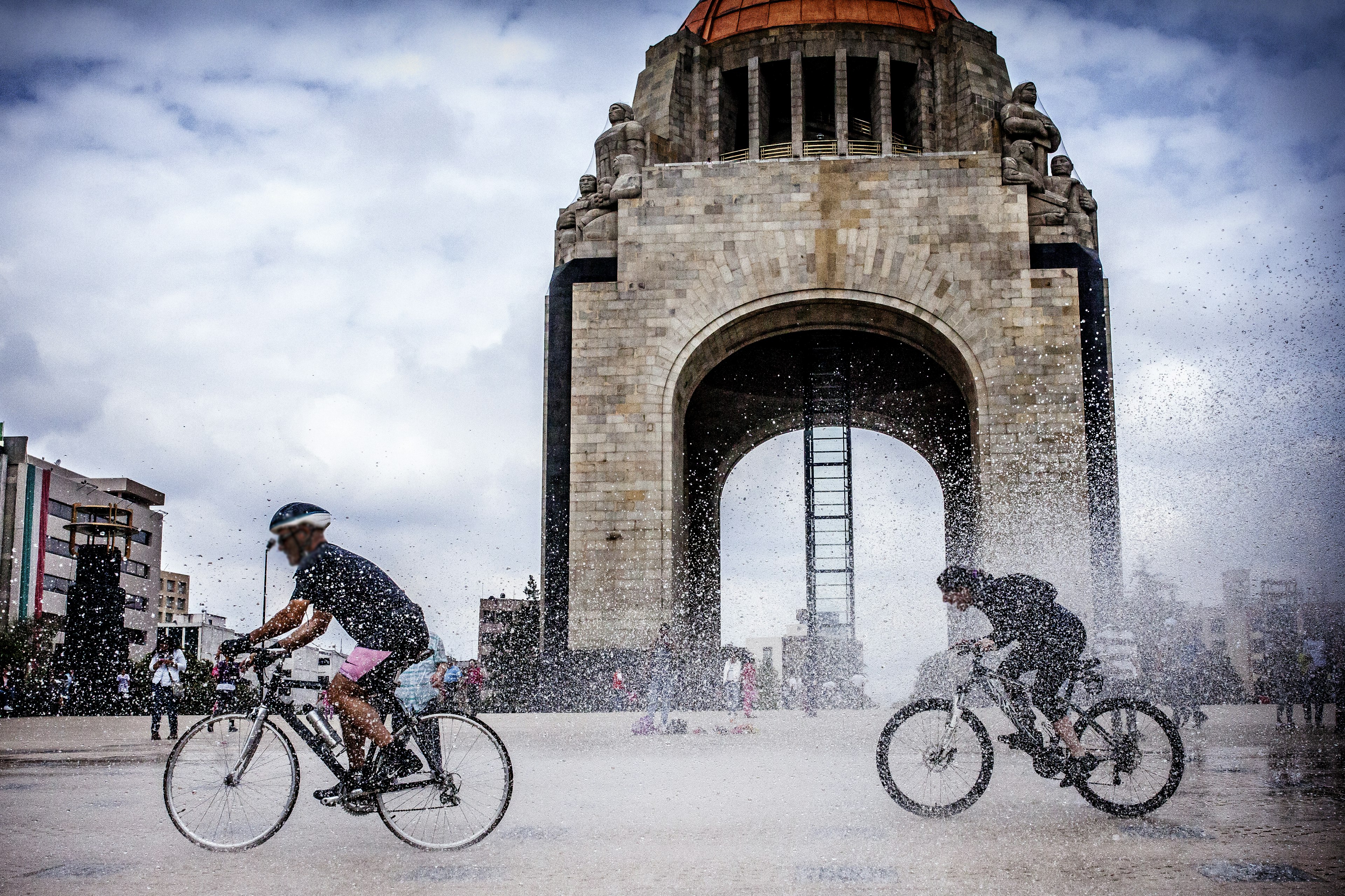 Cyclists ride past the Monumento a la Revolución in Mexico City