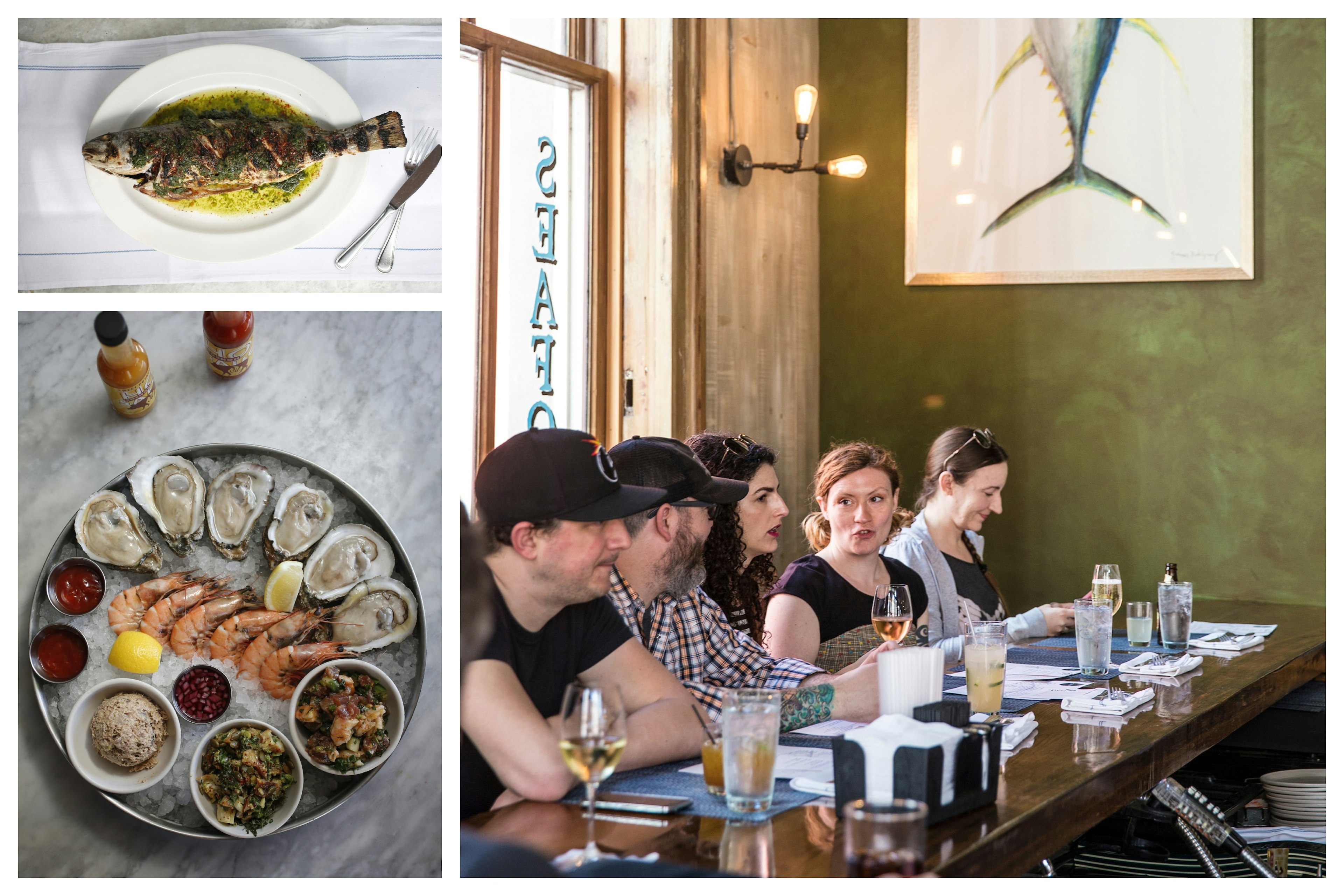 Whole fish, a plate of shrimp and oysters and a party of people enjoying themselves at a bar in a restaurant