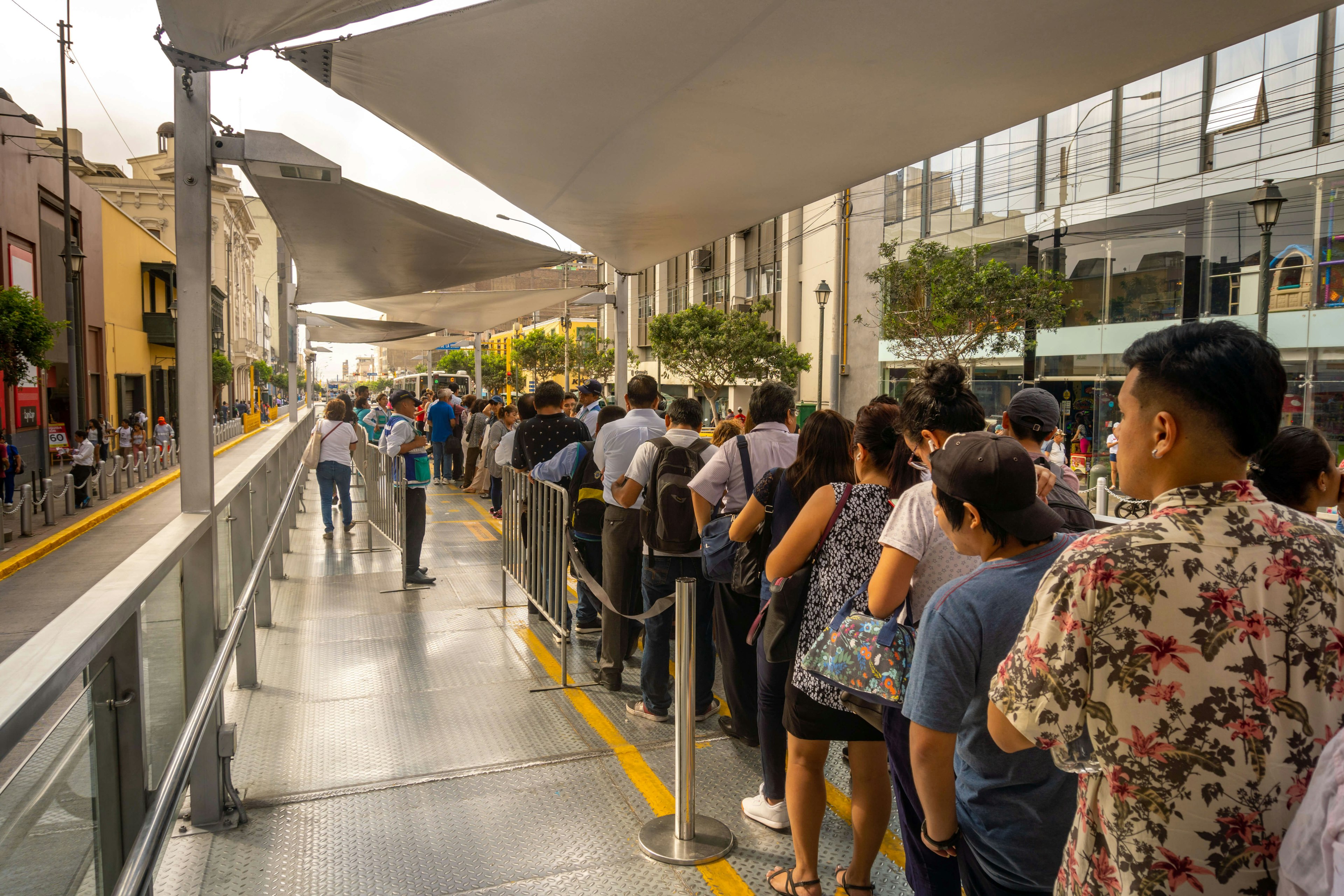 People waiting in line on the platform of a Bus Rapid Transit (BRT) station known as Metropolitano in Lima, Peru