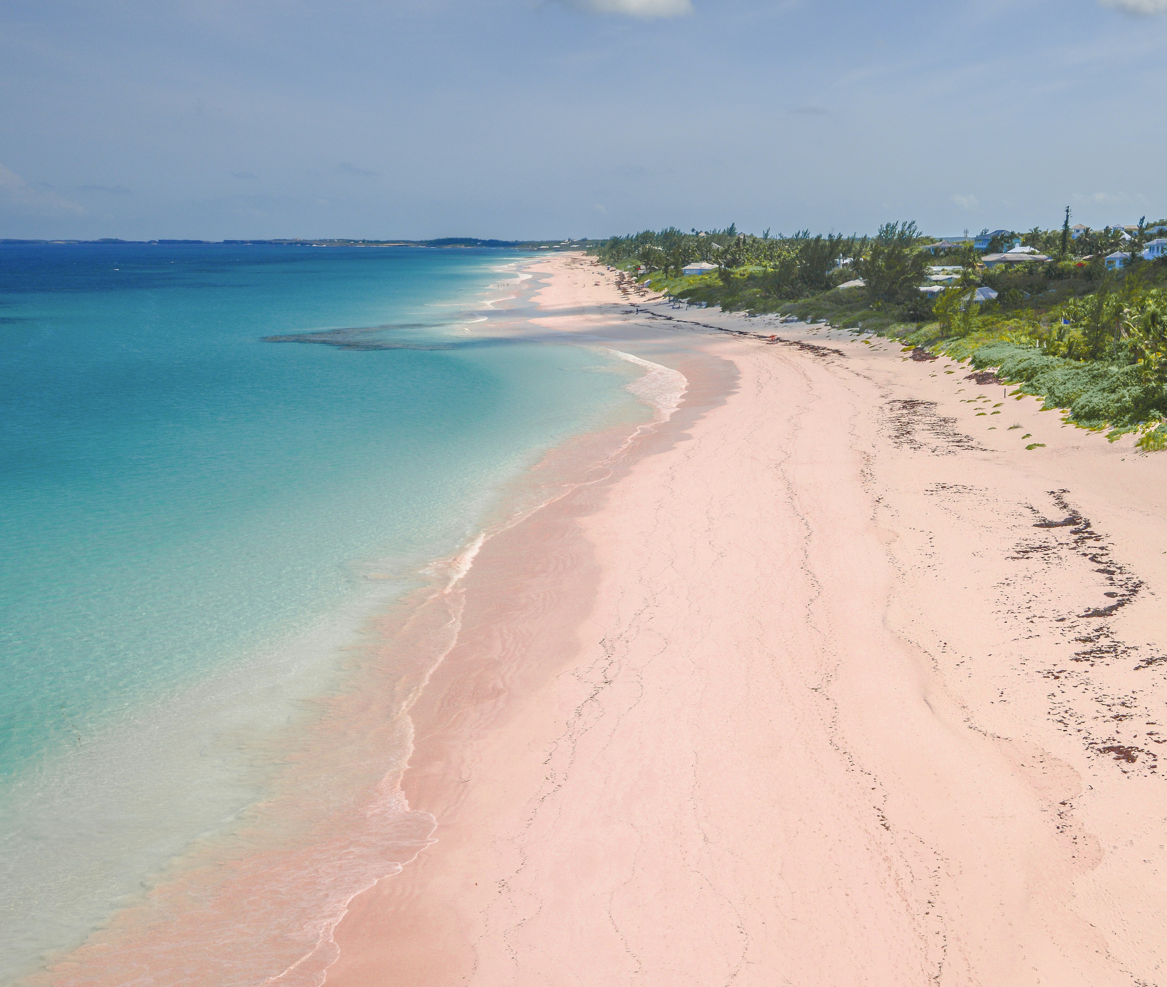 Aerial view of pink sand and blue waters of the aptly named Pink Sand Beach. The