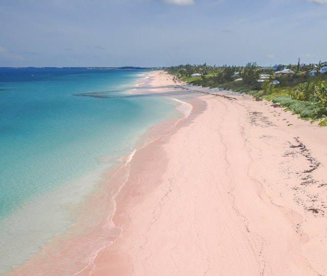 Aerial view of pink sand and blue waters of the aptly named Pink Sand Beach. The