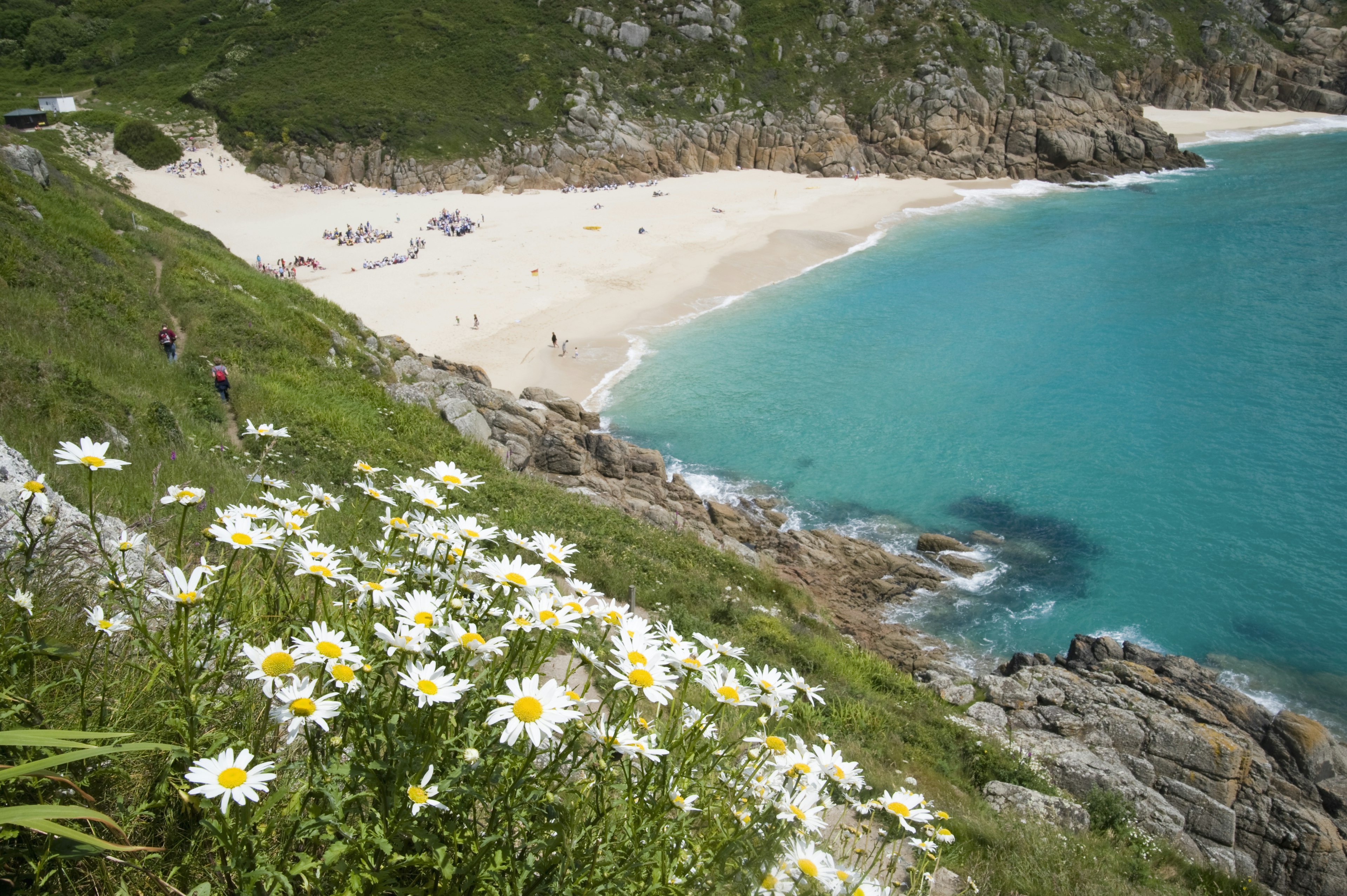 Hikers above Porthcurno Beach near Land's End in Cornwall