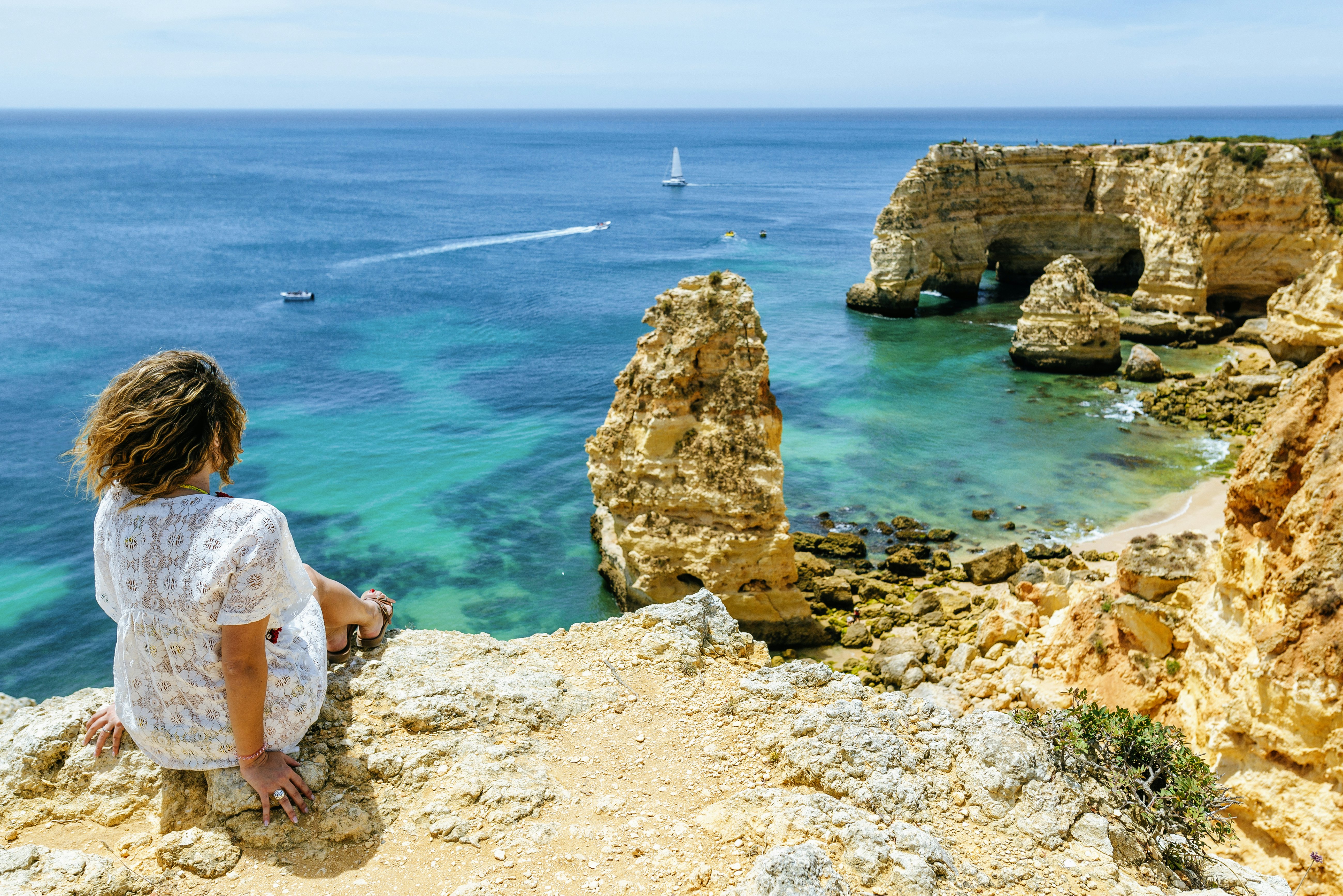 A woman looking at the cliffs at Praia da Marinha, Algarve, Portugal