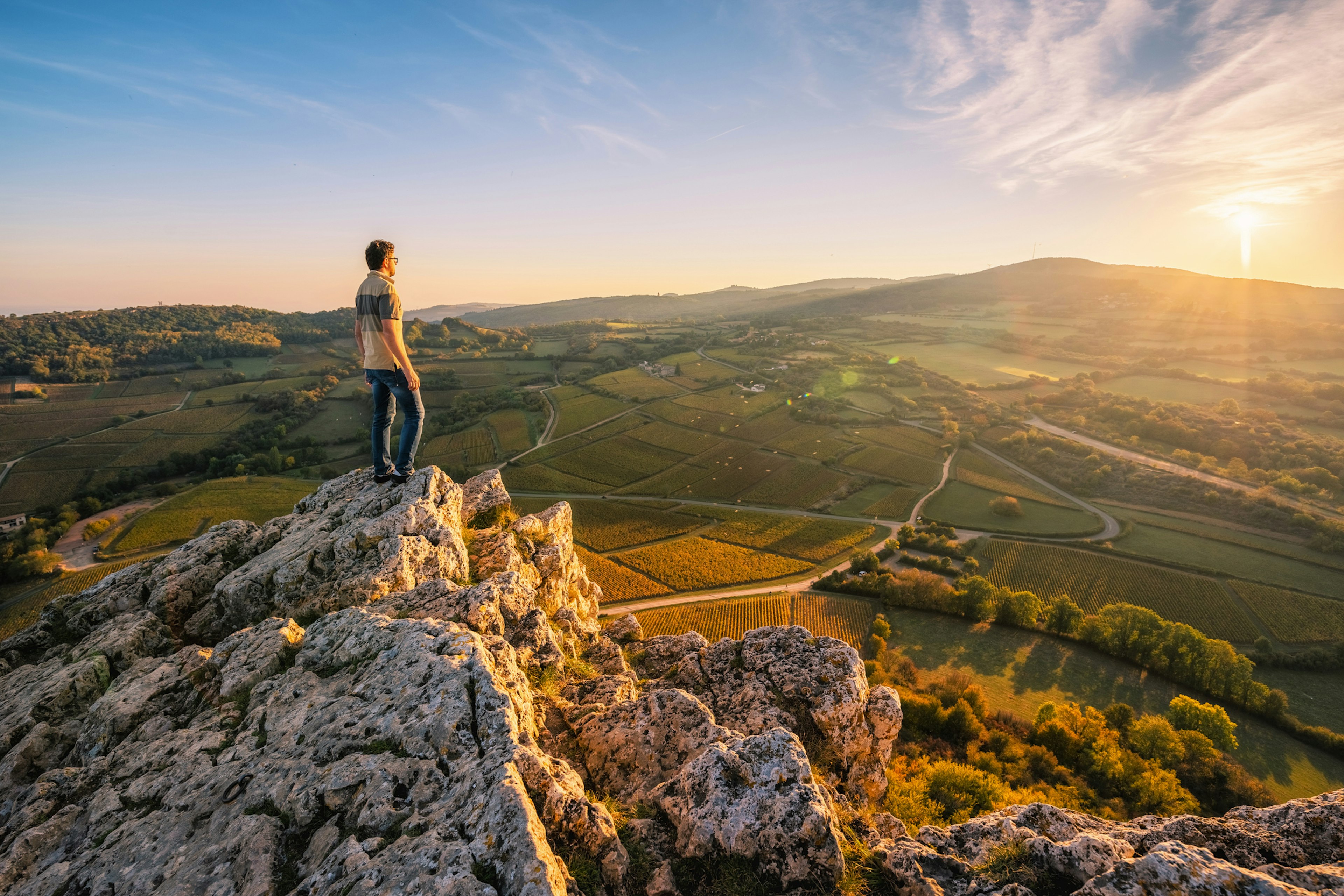 Man standing on the Rock of Solutre at sunset, Burgundy