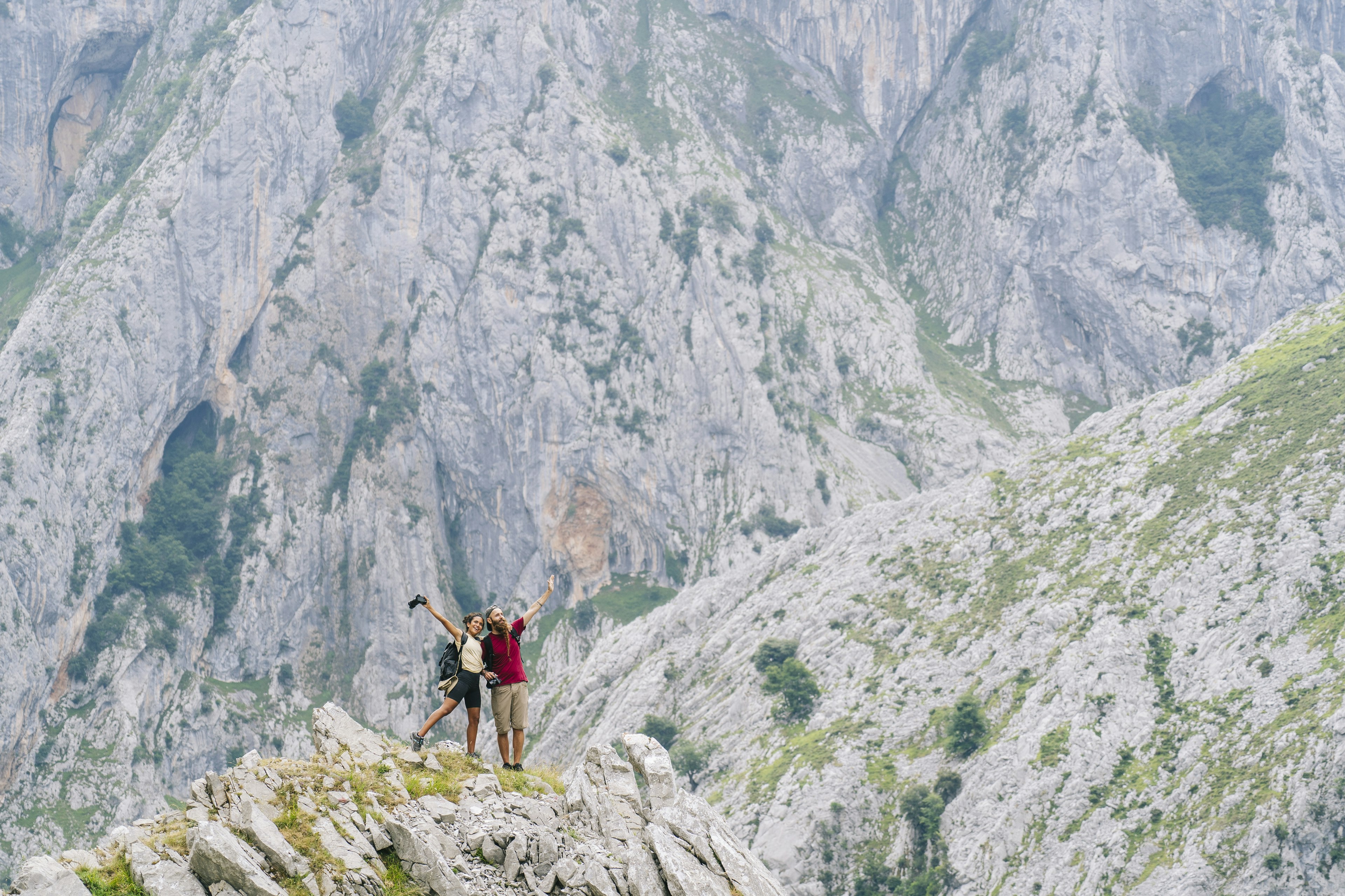 Carefree couple admiring the view while standing on mountain at Ruta Del Cares, Asturias, Spain