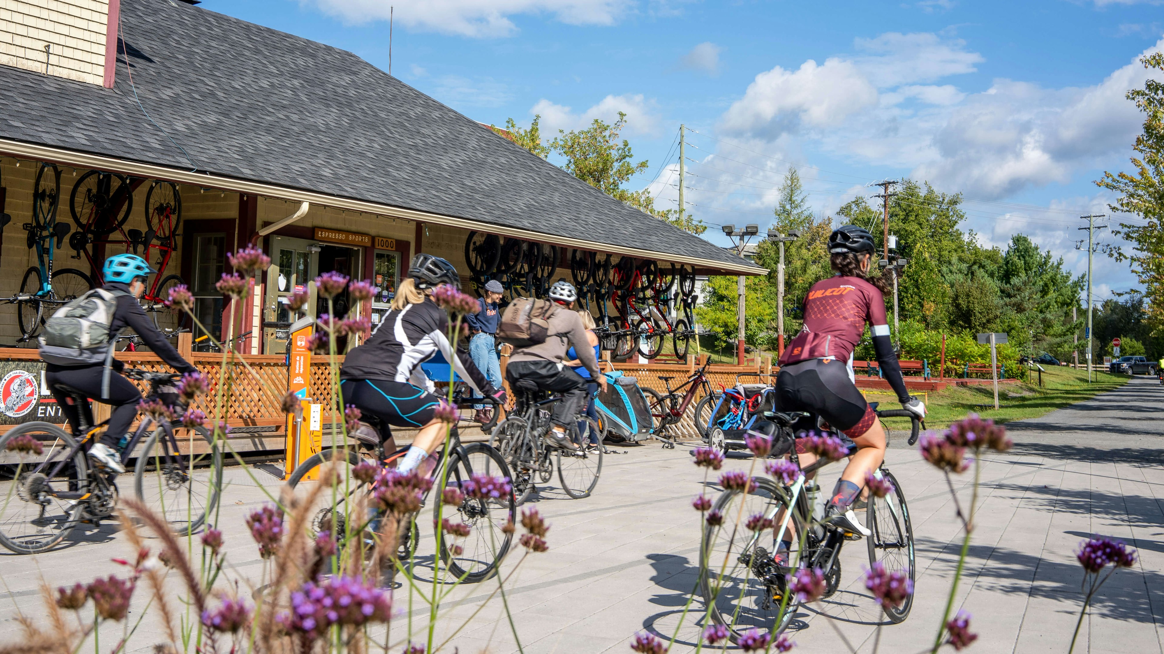 Cyclists pass a bike shop on the Route Verte