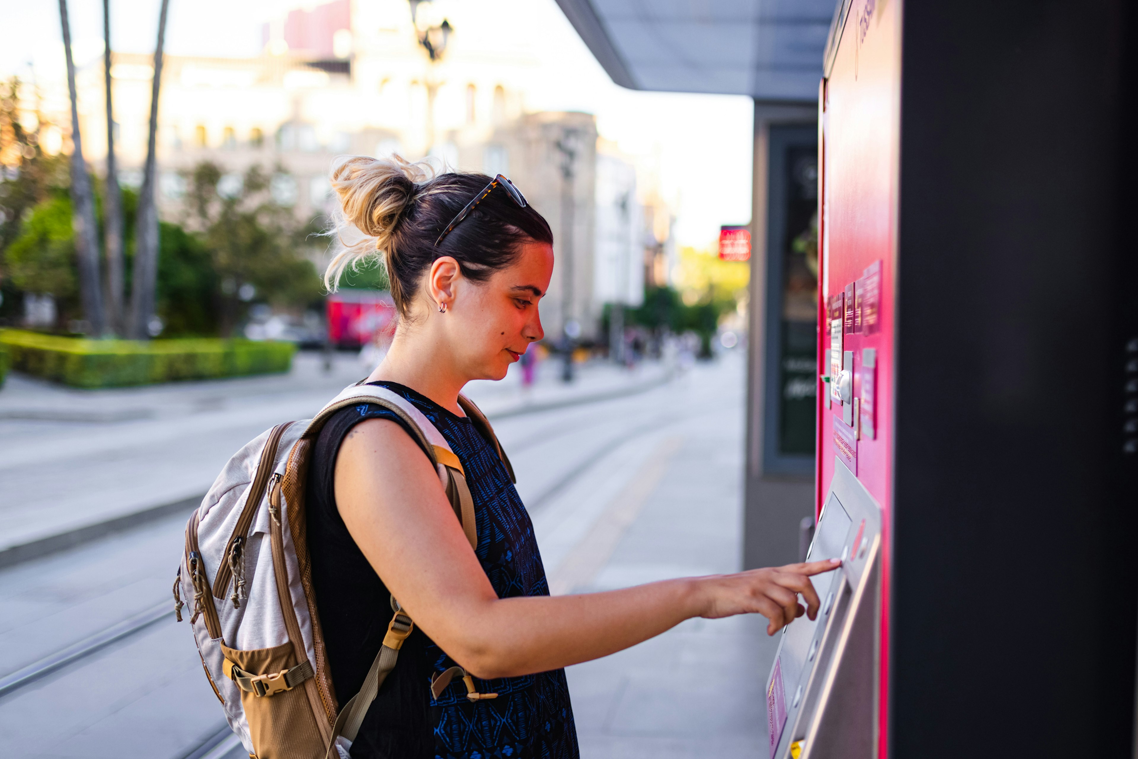 Young woman buying ticket for transportation