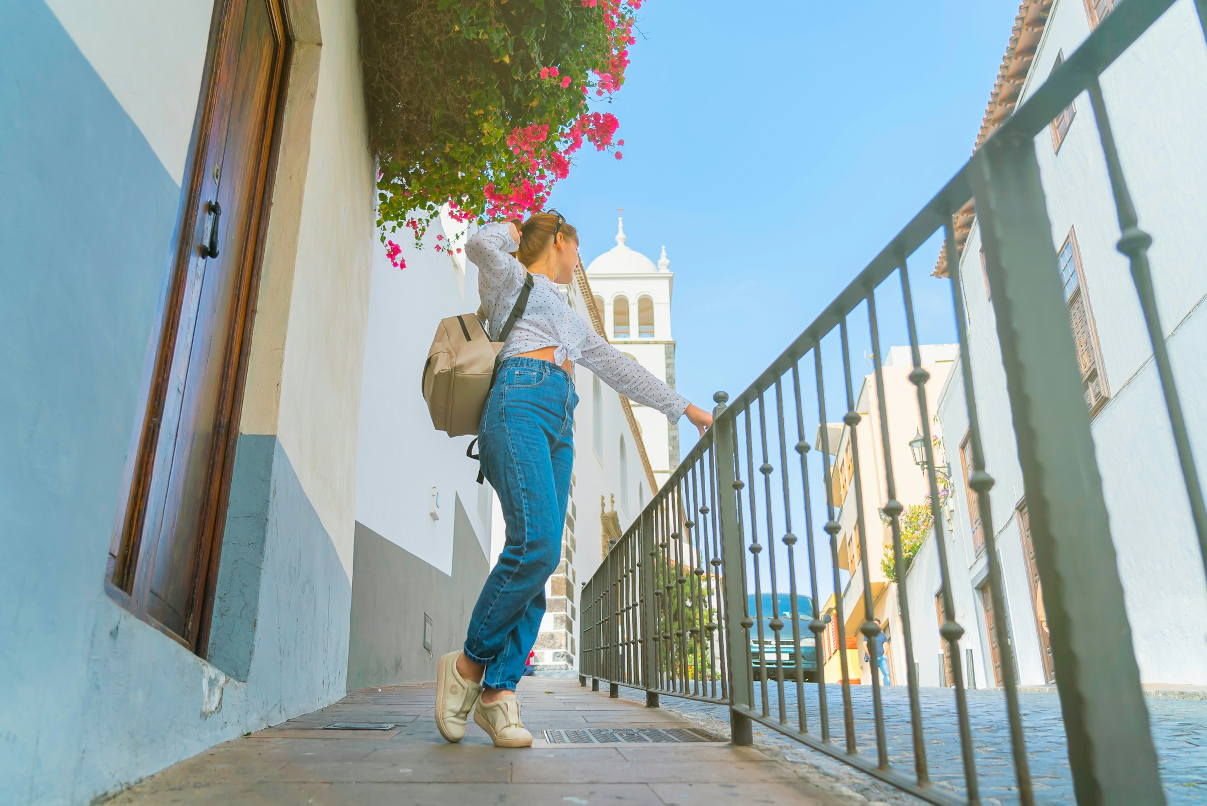 White girl with a small backpack on the streets of Garachico, Tenerife on a sunny day.