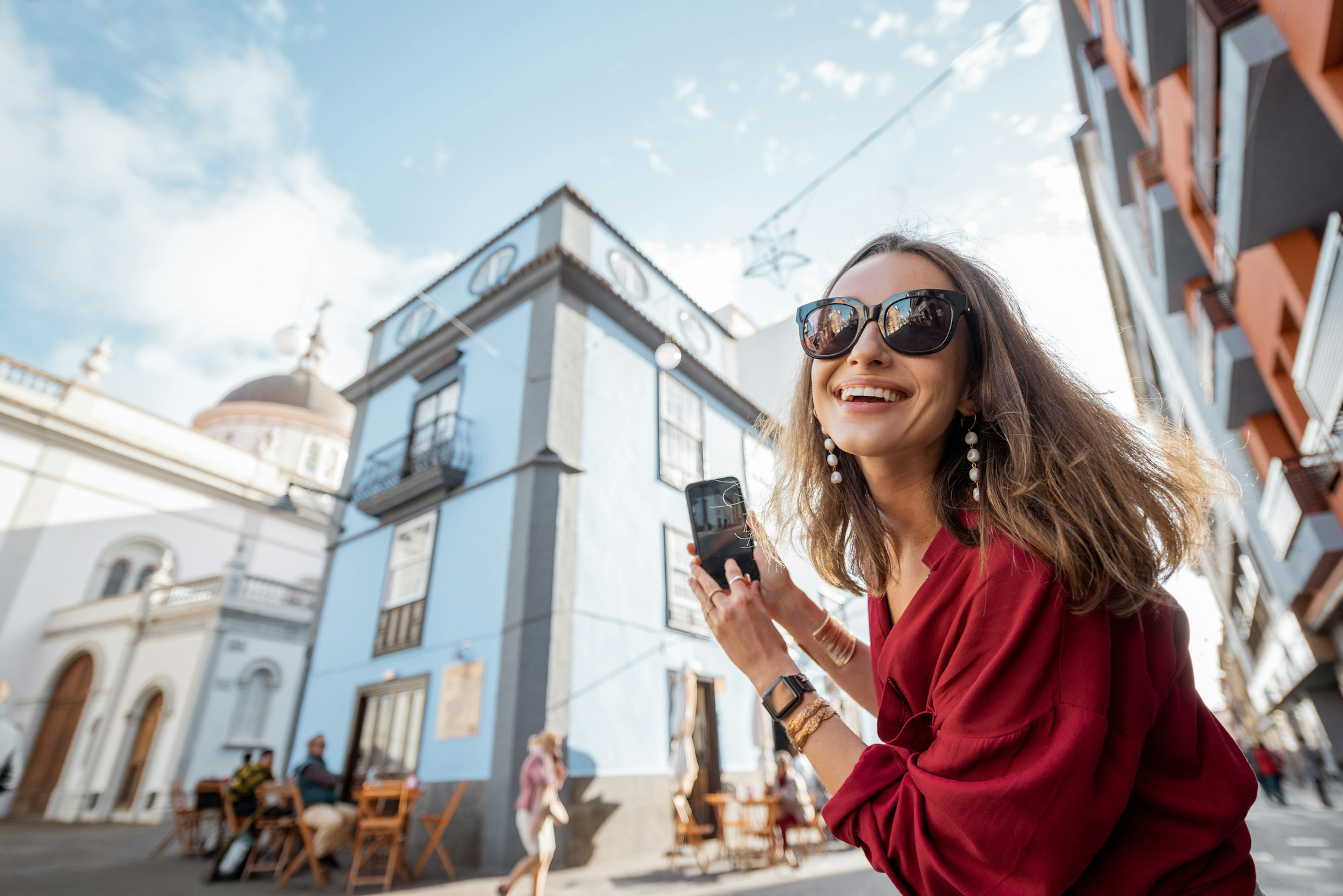 White woman smiling in La Laguna old town city on Tenerife, Spain with a blurry historic building in the background