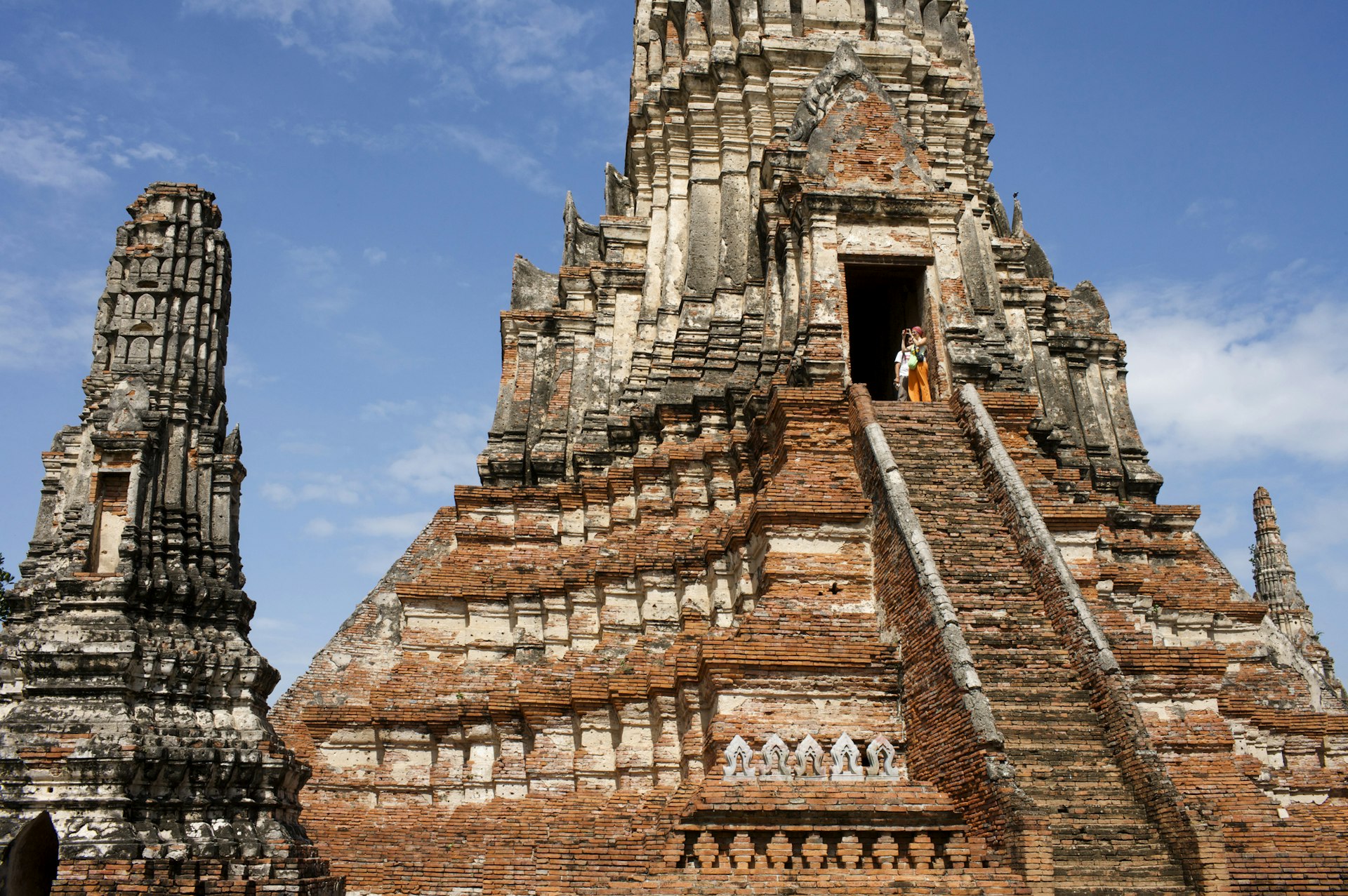 Travelers climb the steps to Wat Chaiwattanaram in Ayutthaya, Thailand. 