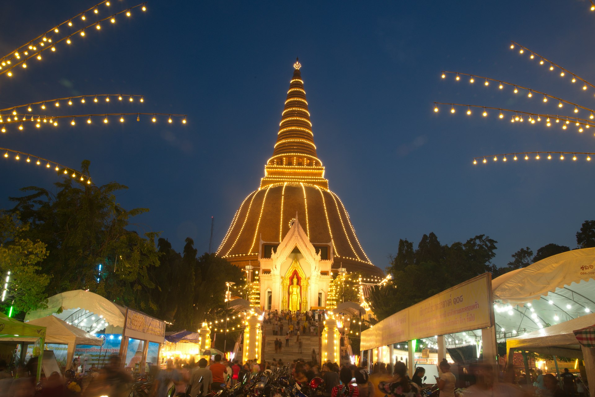 Buddhists gather at Phra Pathom Chedi in Nakhon Pathom at dusk.