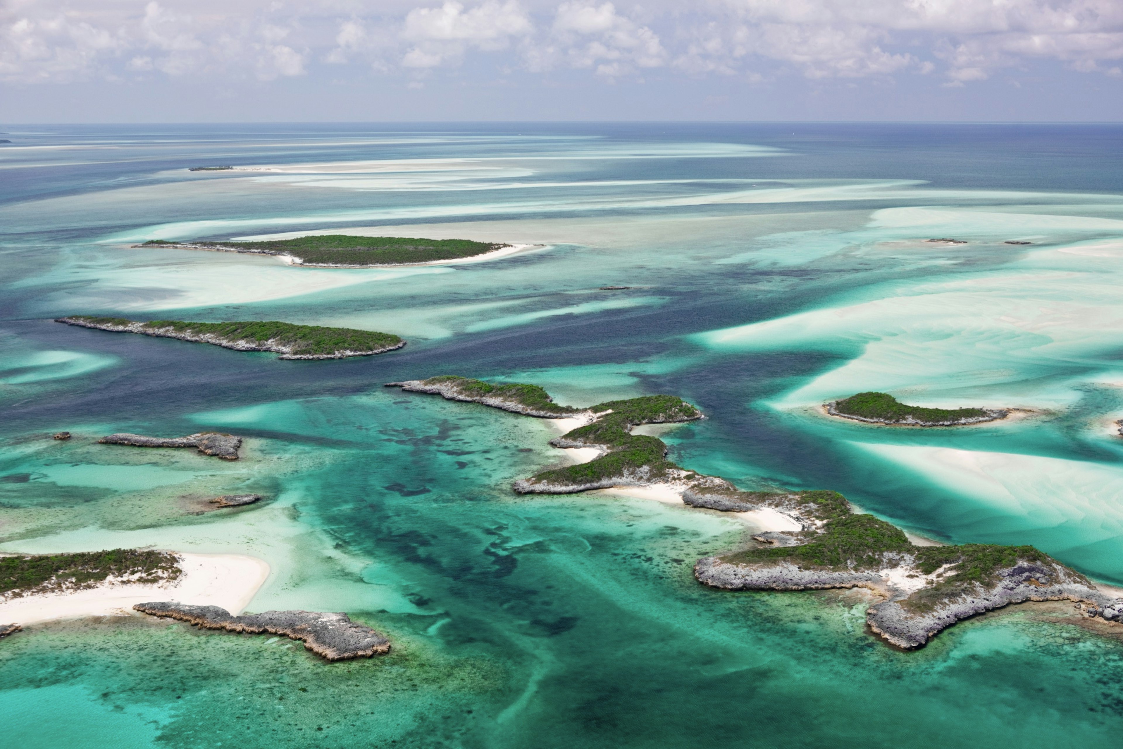 Aerial view of the islands, beautiful sandy bottom and green water contours of the Exumas in the Bahamas.