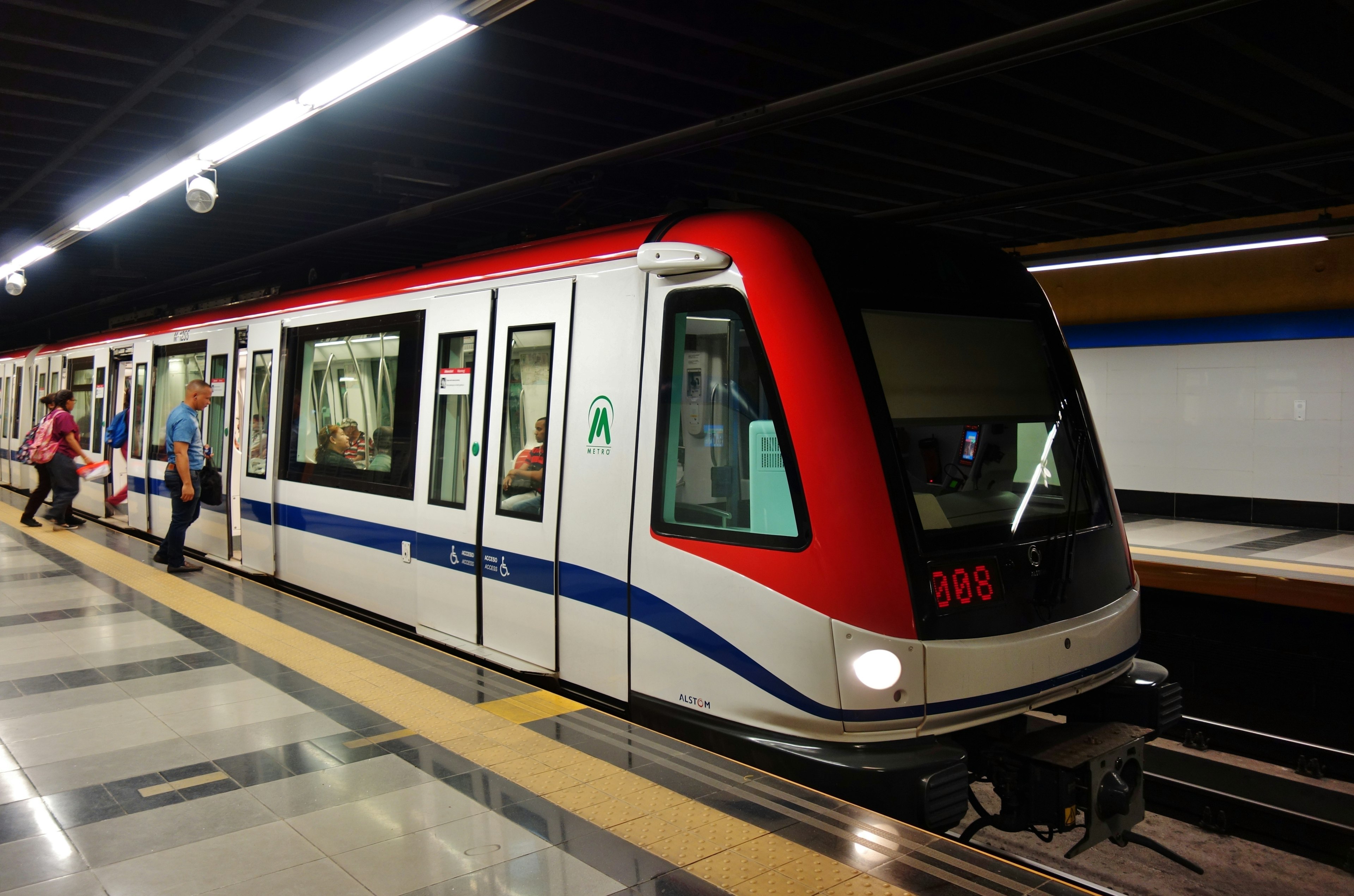 Passengers board a red, white and blue train stopped at a metro station in Santo Domingo, Dominican Republic.