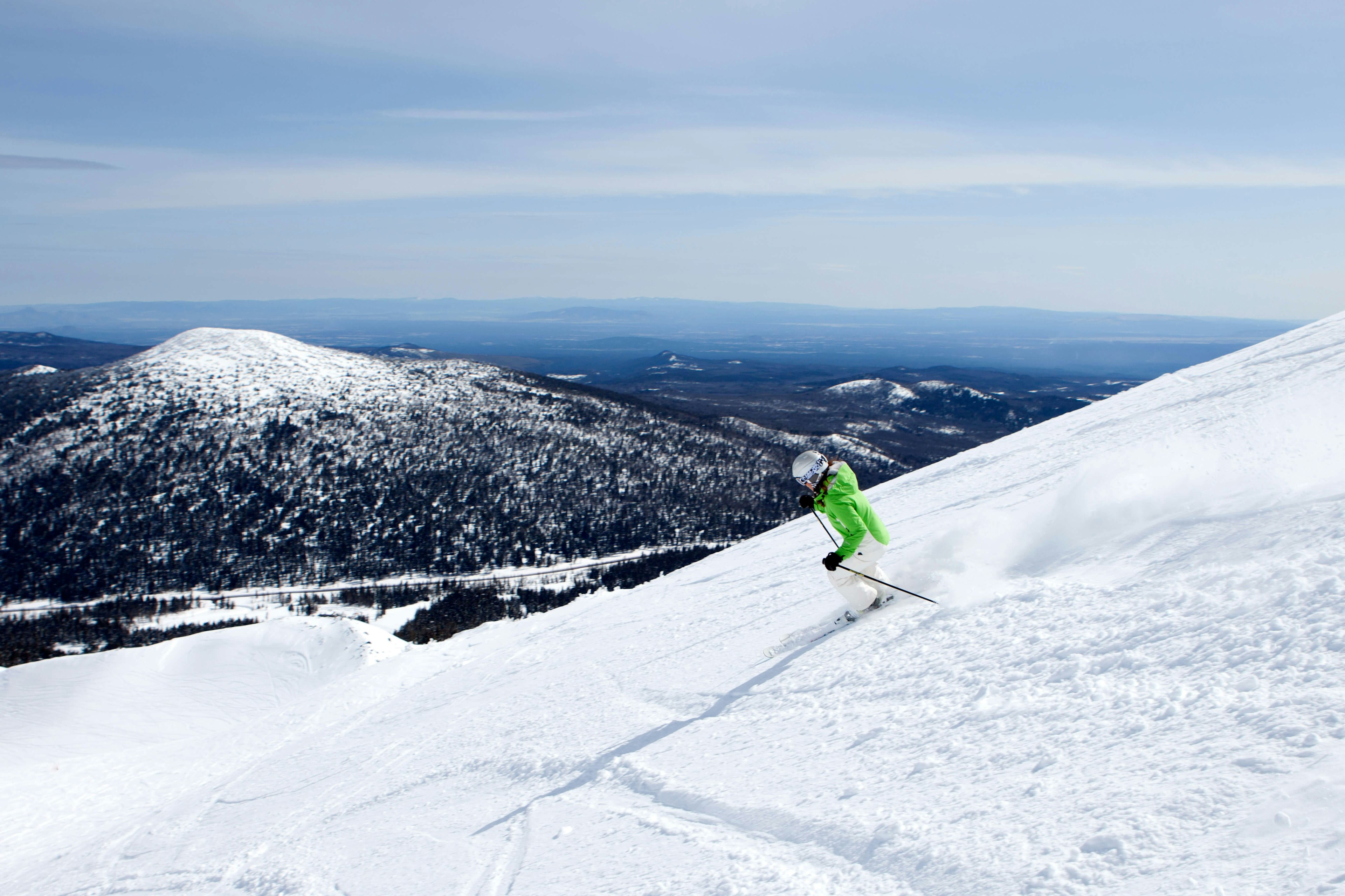 A woman in neon green, skiing at Mt. Bachelor resort in Bend, Oregon