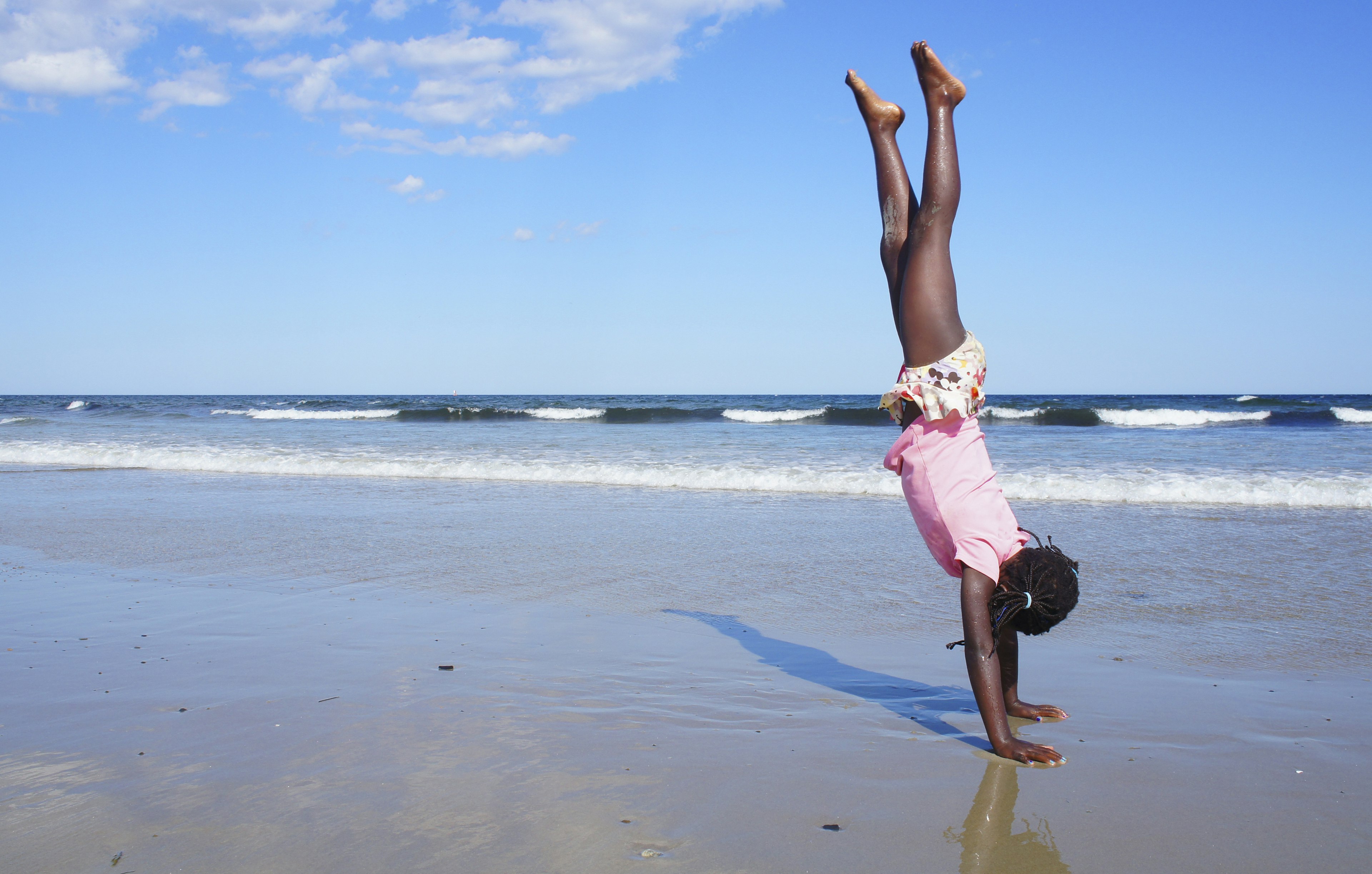 Girl doing a handstand on a Maine beach