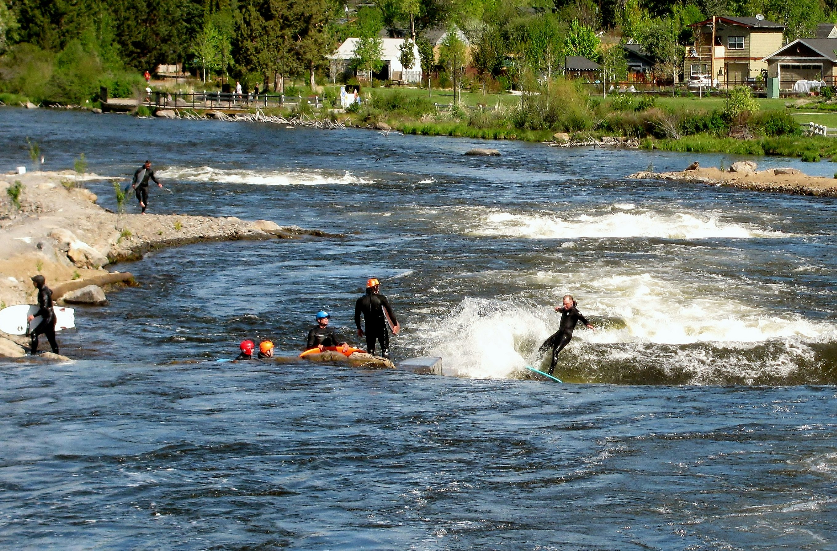 Group of people river surfing in the whitewater park at Deschutes River.