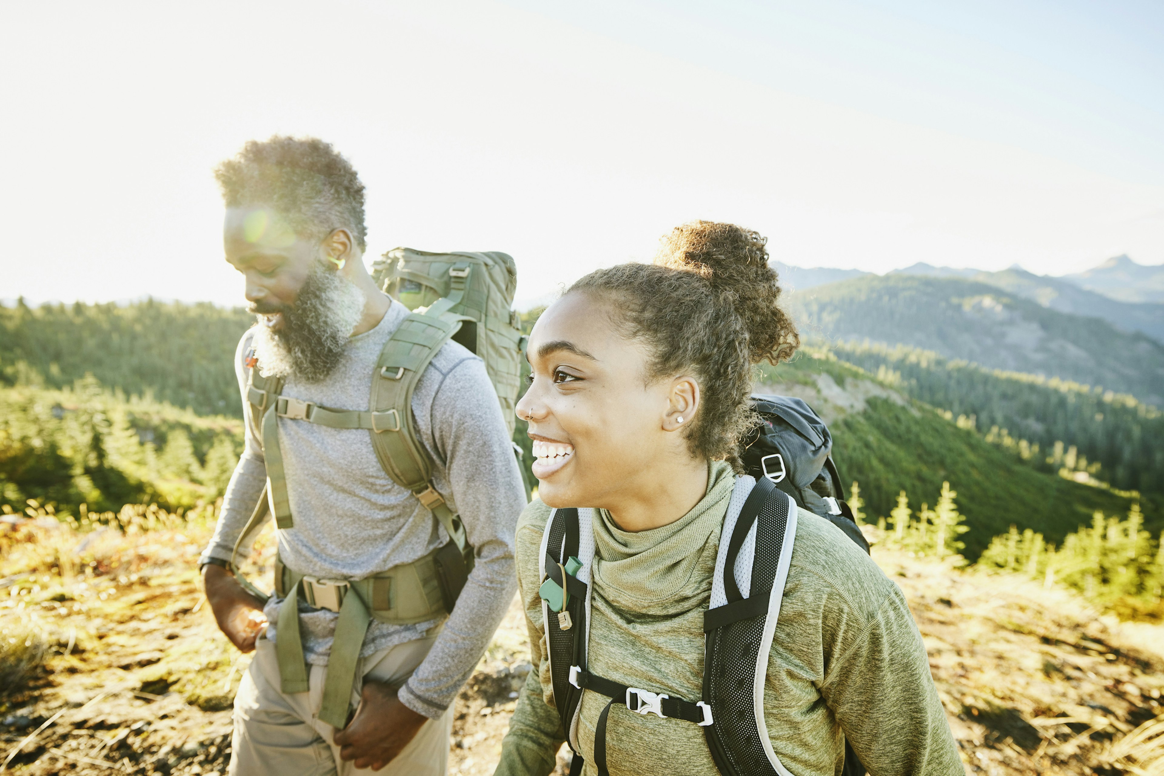 Smiling daughter and father on backpacking trip on fall afternoon