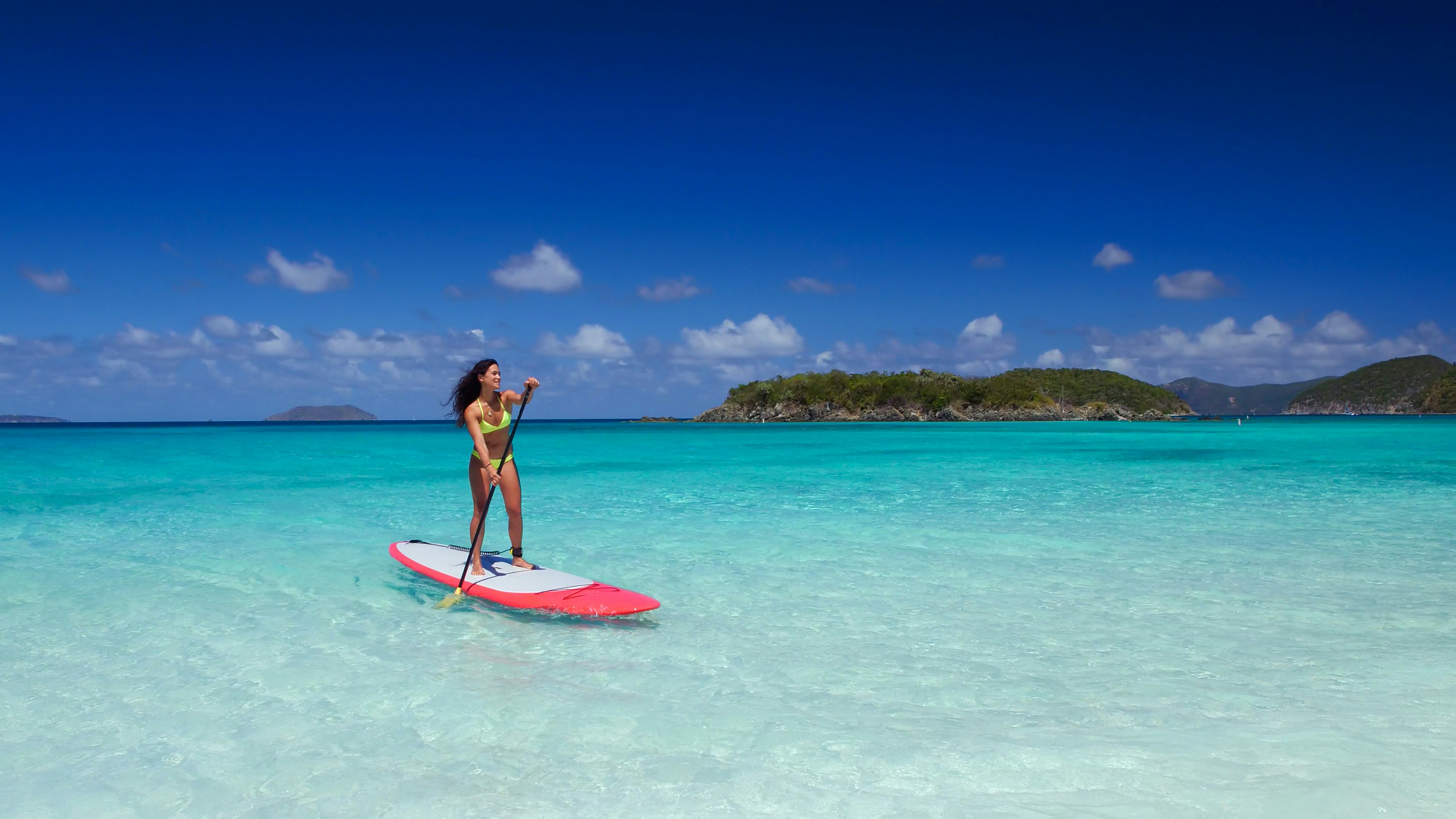 young attractive multi-ethnic woman on paddle board at cinnamon bay, United States Virgin Islands