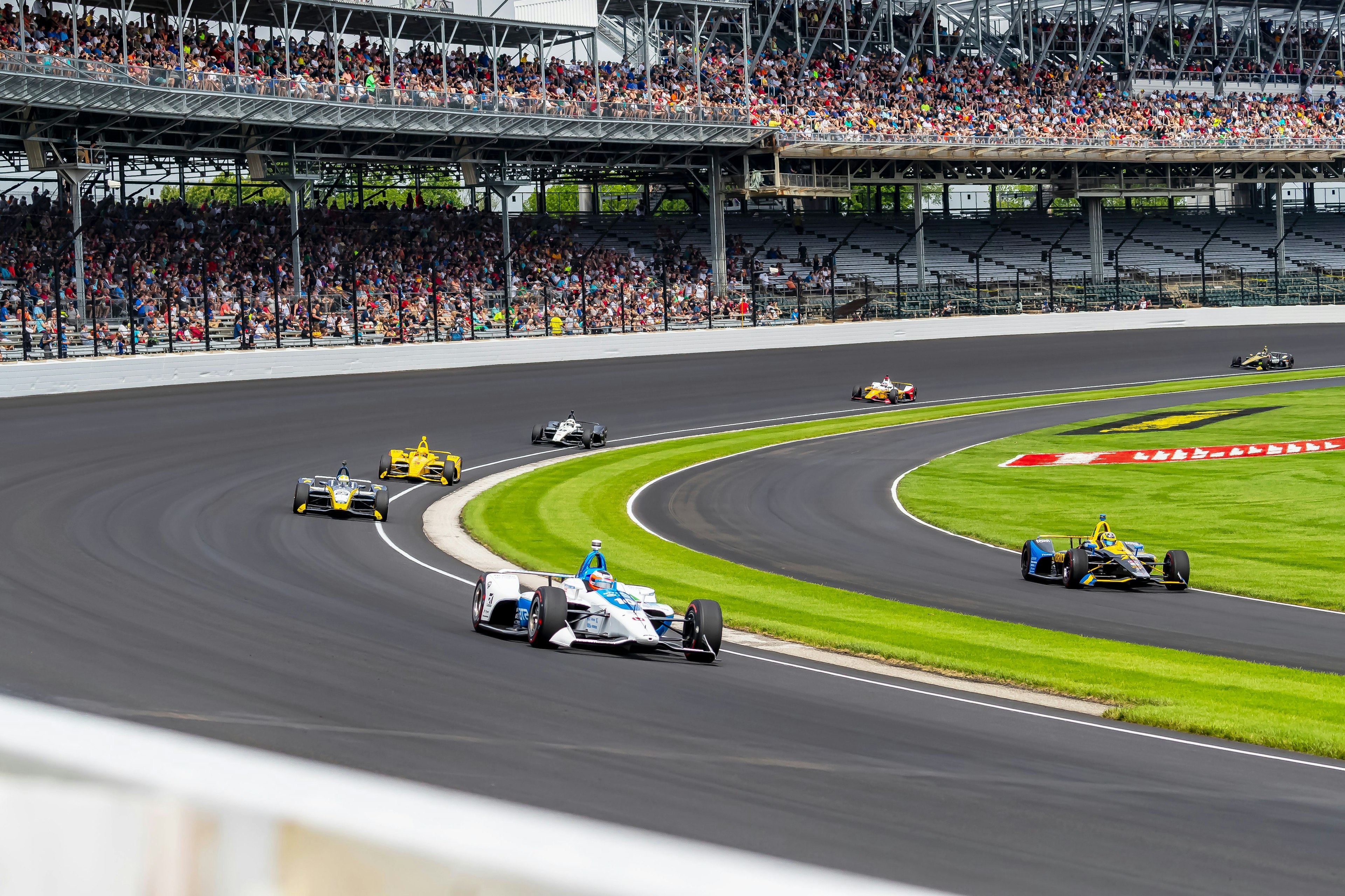 Cars race around the Indianapolis Motor Speedway