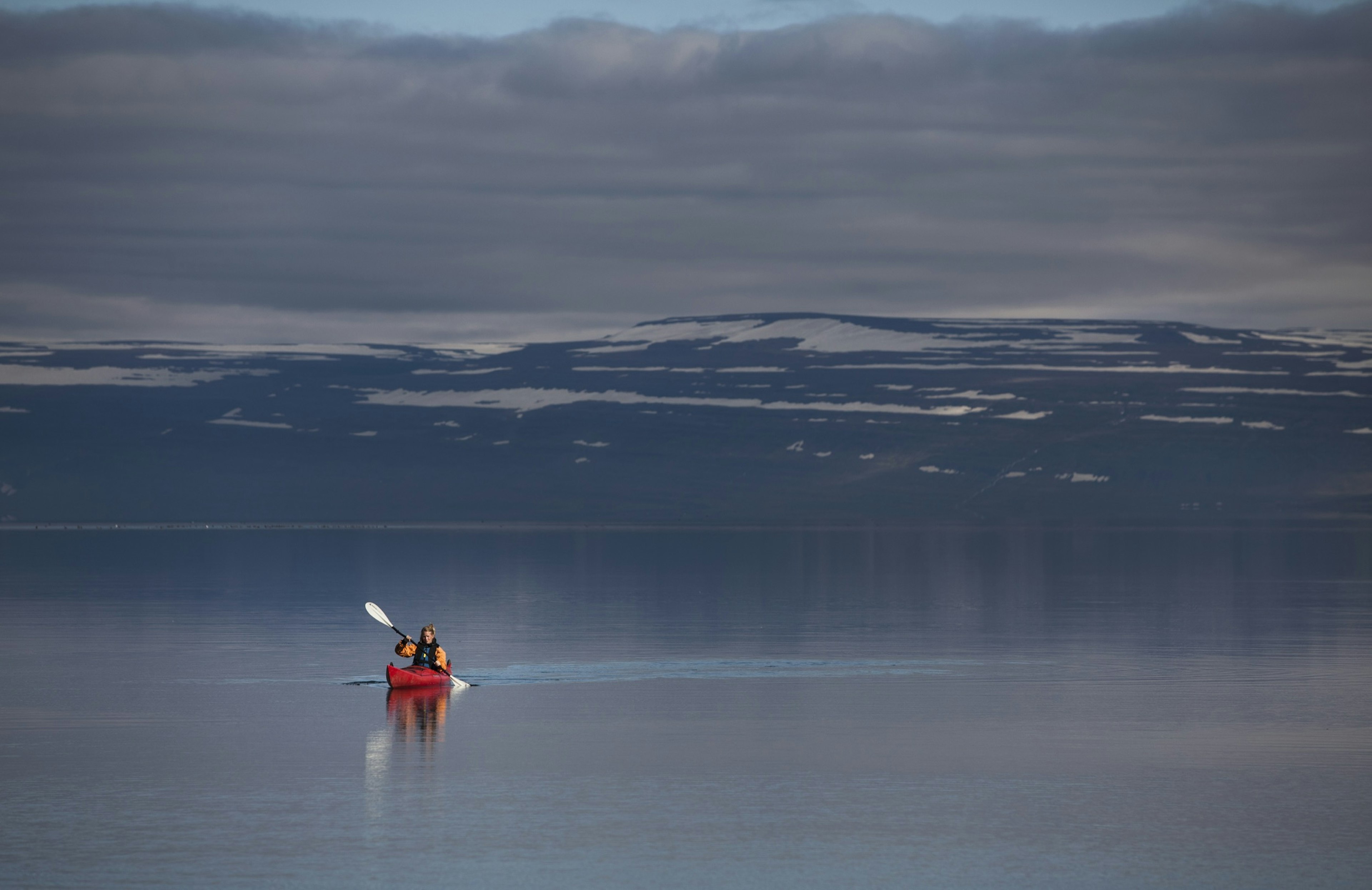 Woman kayaking in still lake