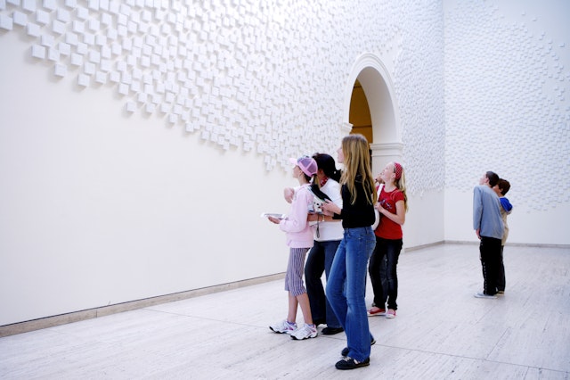 A groupd of young people look at artworks in a city gallery