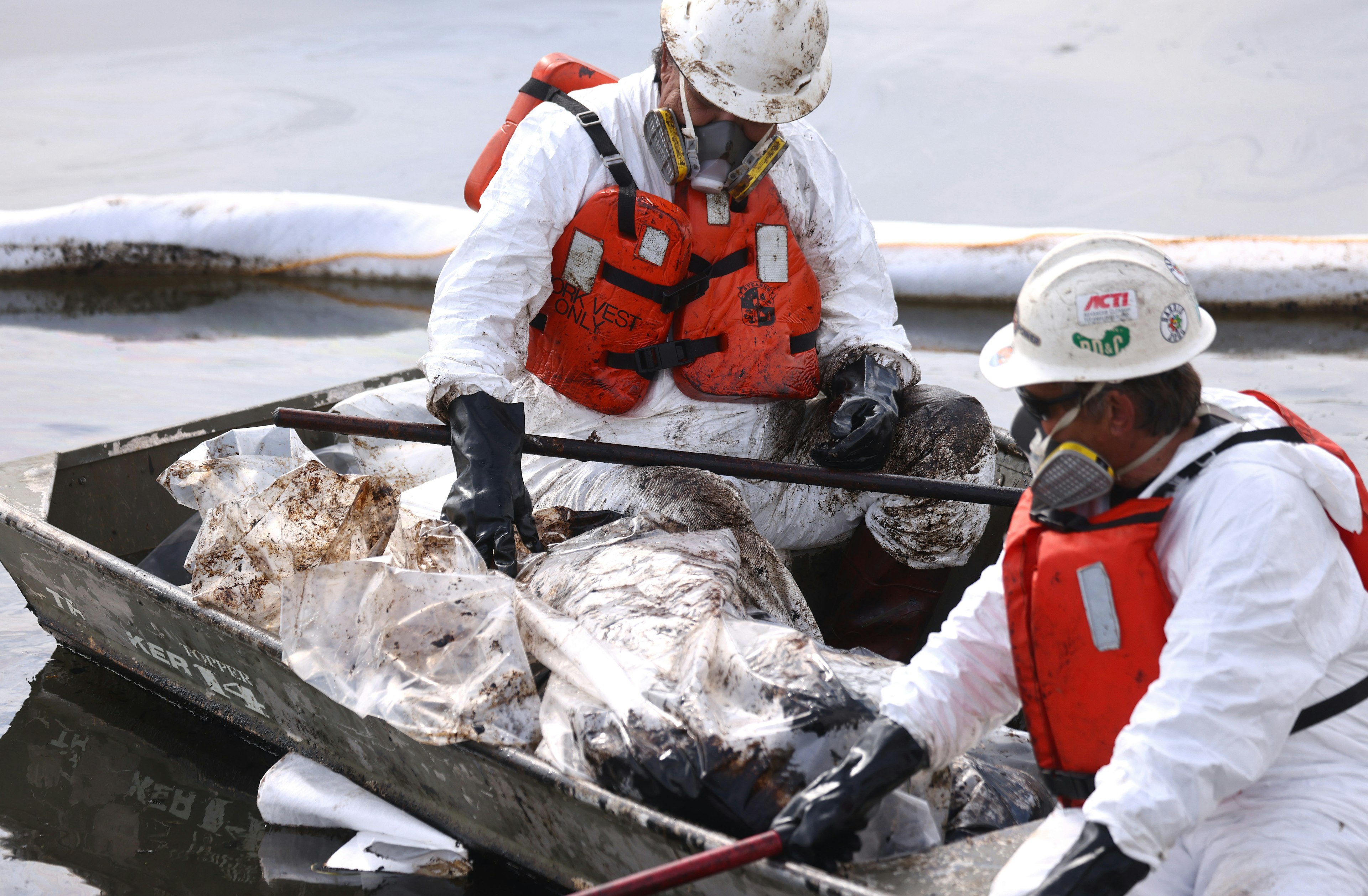 Workers in protective suits clean oil in the Talbert Marsh wetlands