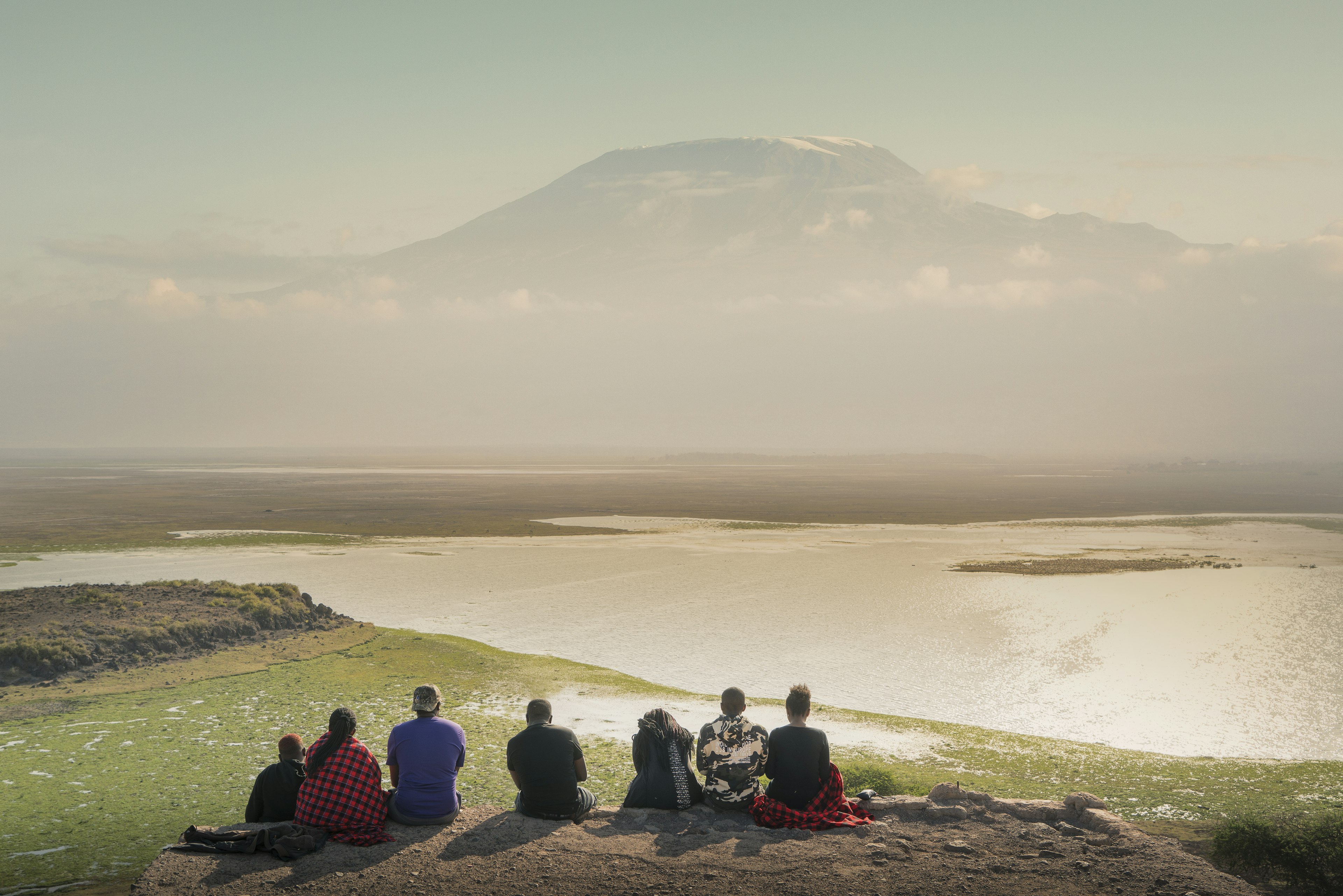 A group of tourists watching sunset over Mount Kilimanjaro