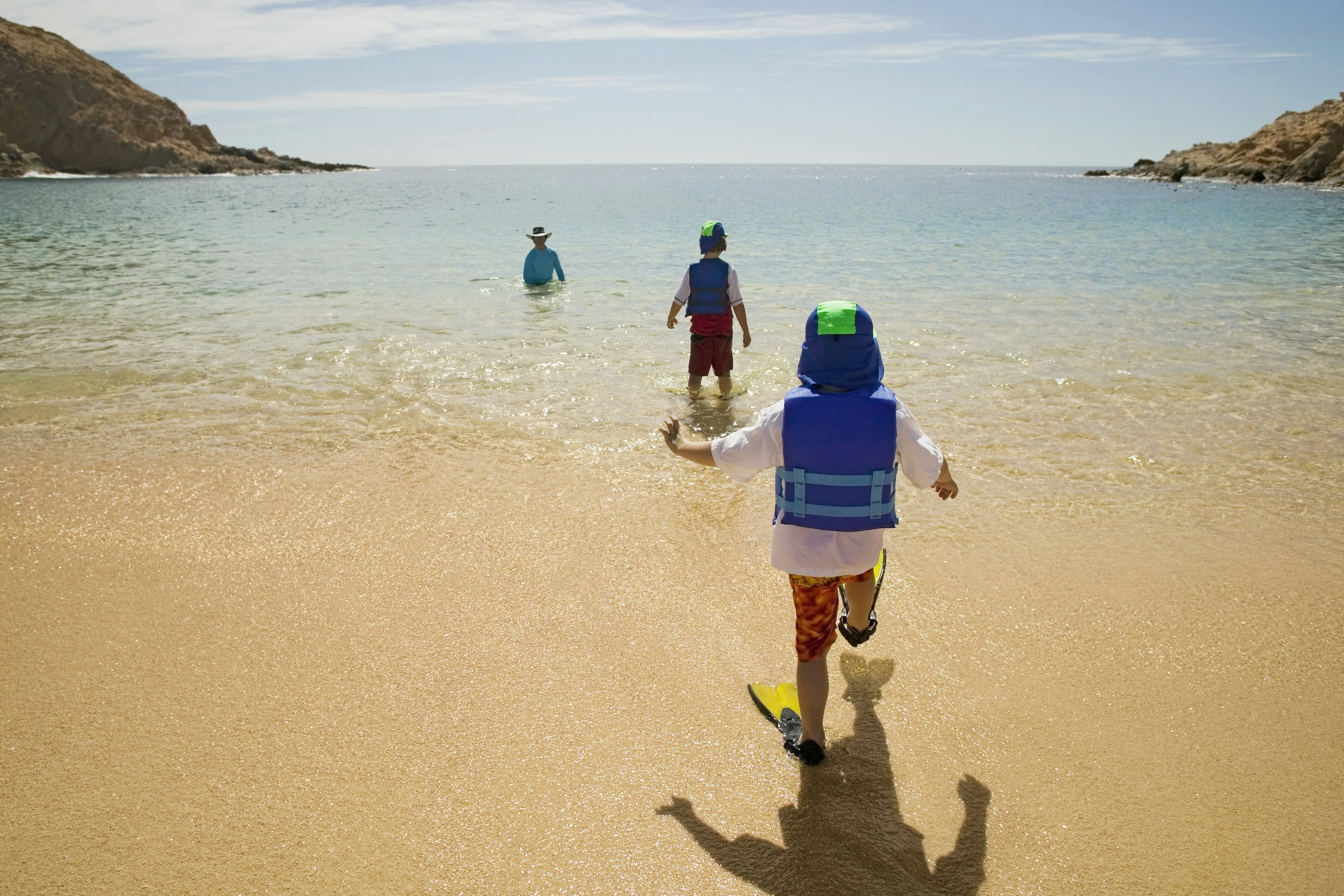 father and sons playing on beach Cabo San Lucas Mexico