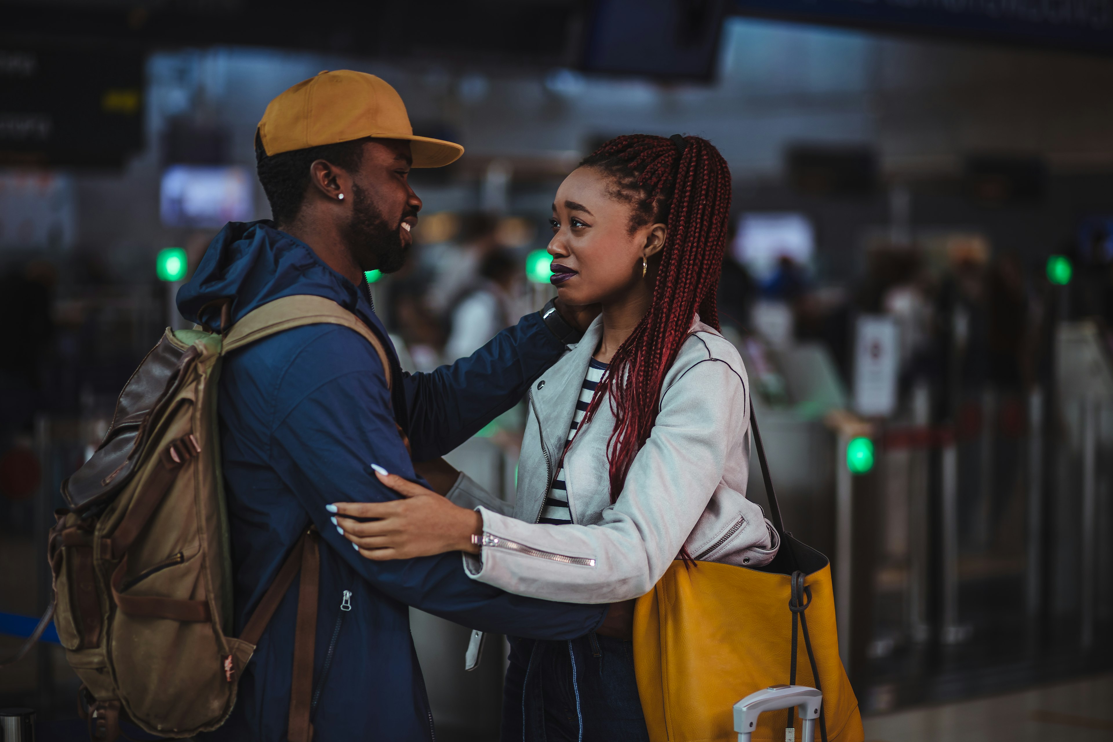 Young couple embracing and saying emotional farewell at airport