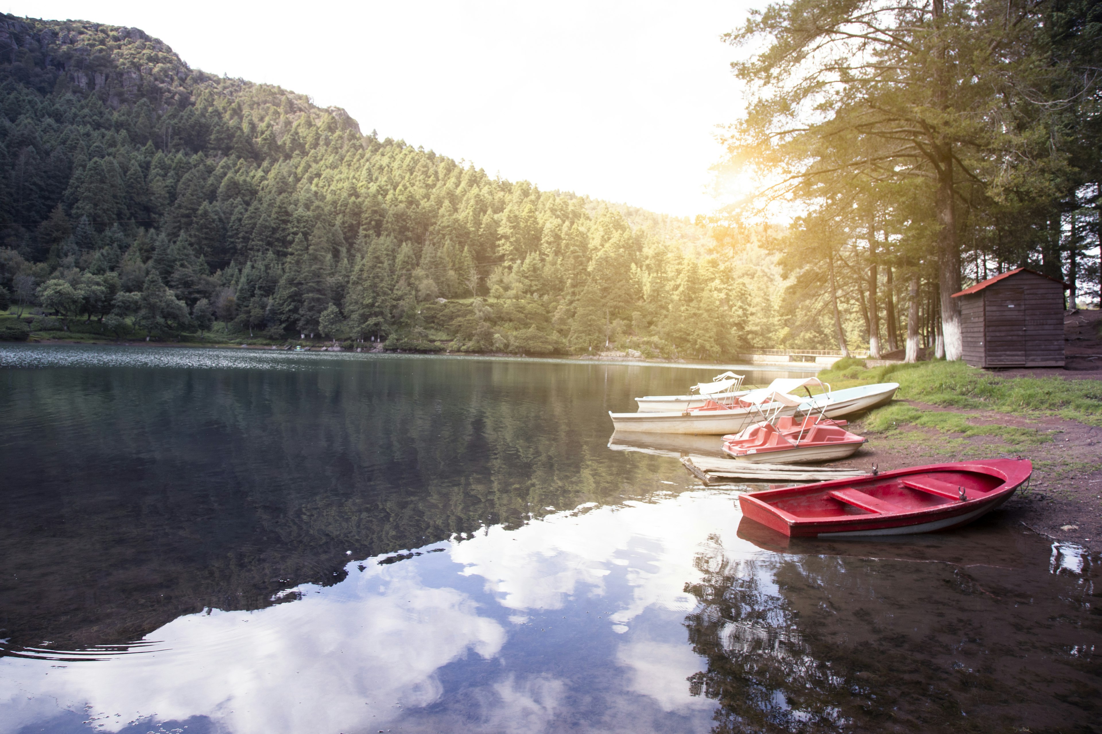 Red and white boats on Mexican lake in the mountains during sunrise