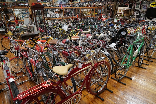 A room packed full of vintage cycles, covering the floor and stacked on a double-decker unit