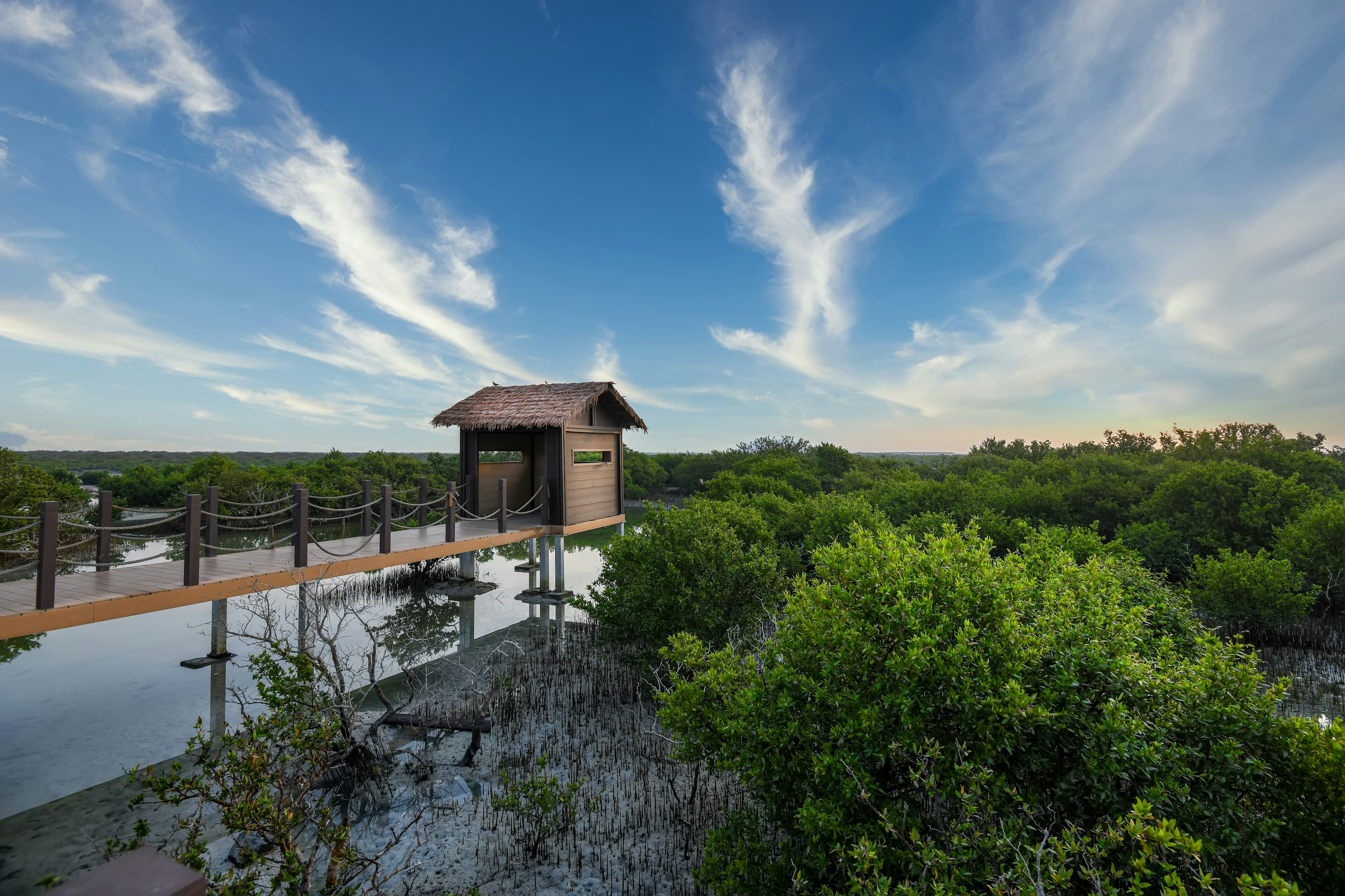 A hut in Al Khor at the end of a bridge that looks over some mangroves