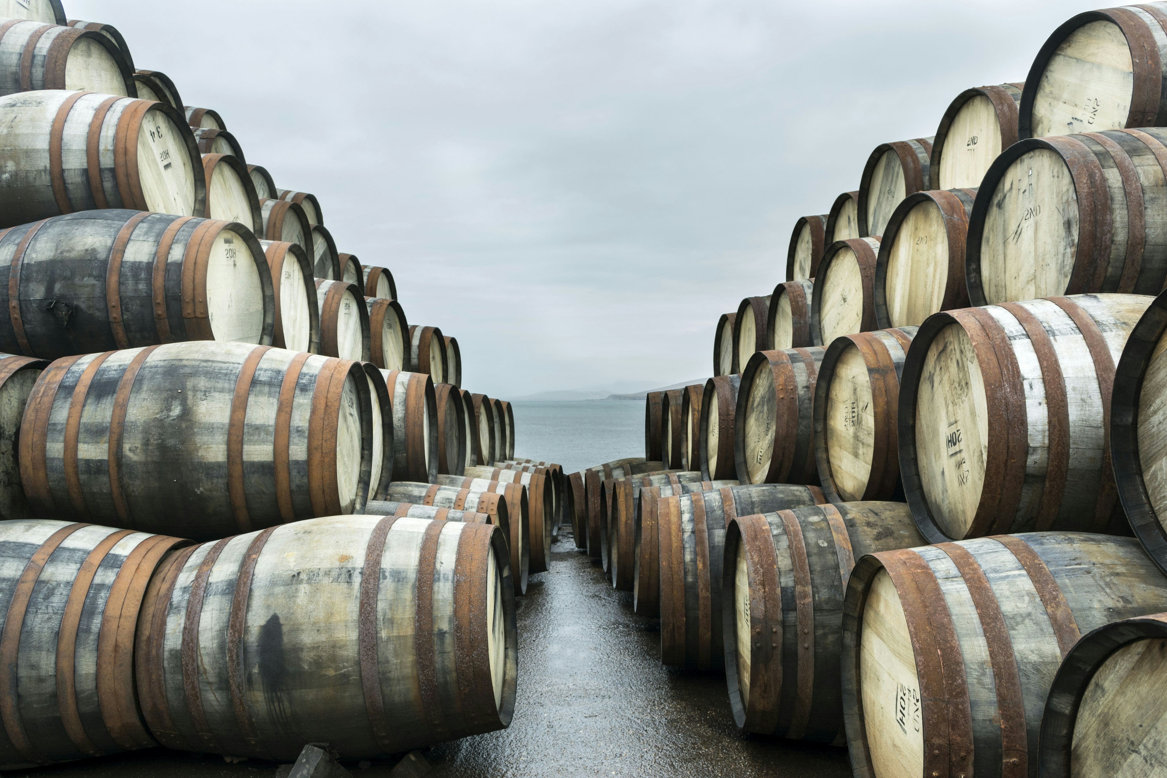 Two large stacks of whisky casks sit outside Bunnahabhain distillery, Isle of Islay, waiting to to be filled with whisky and stored