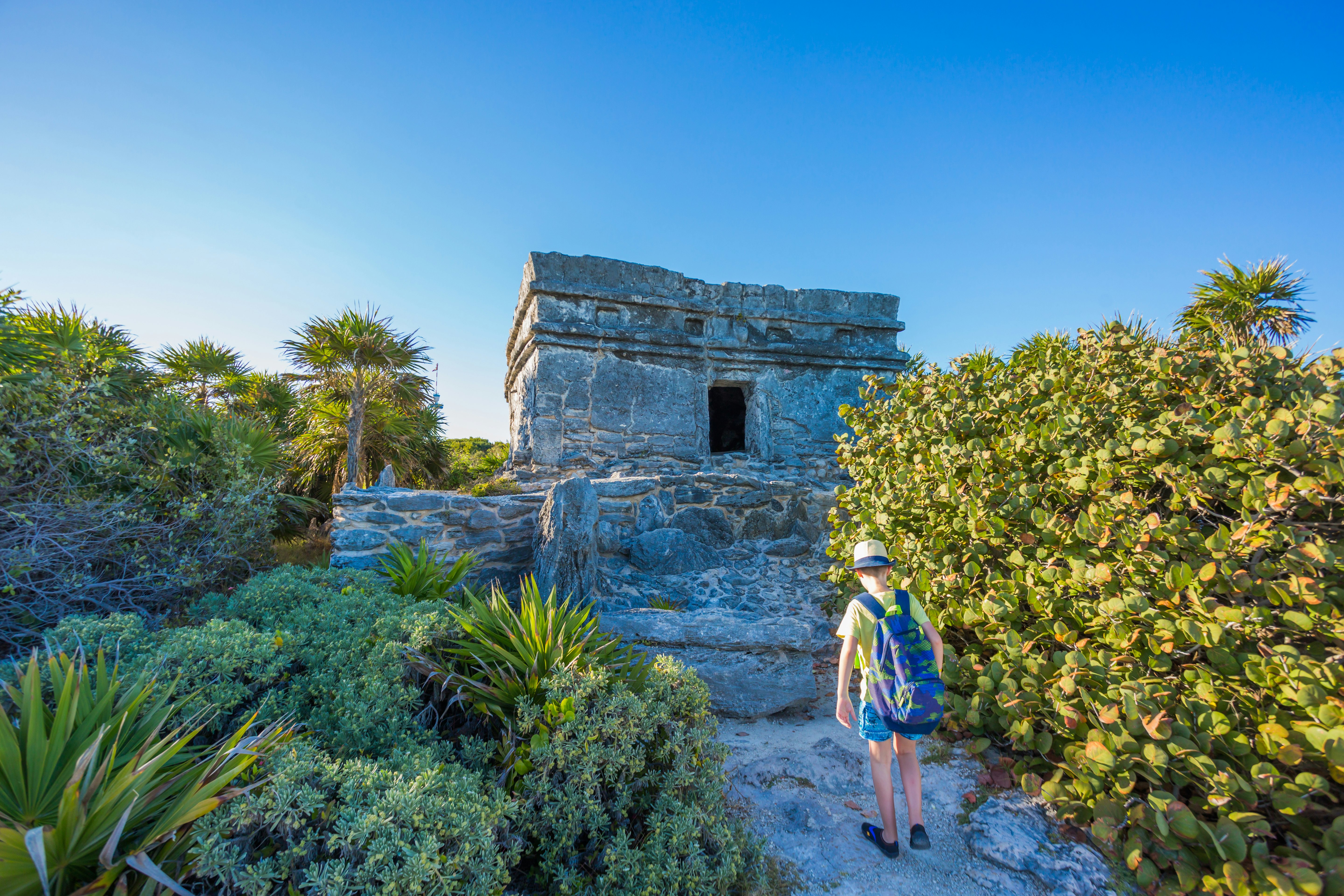 A child exploring Tulum's Mayan ruins alone