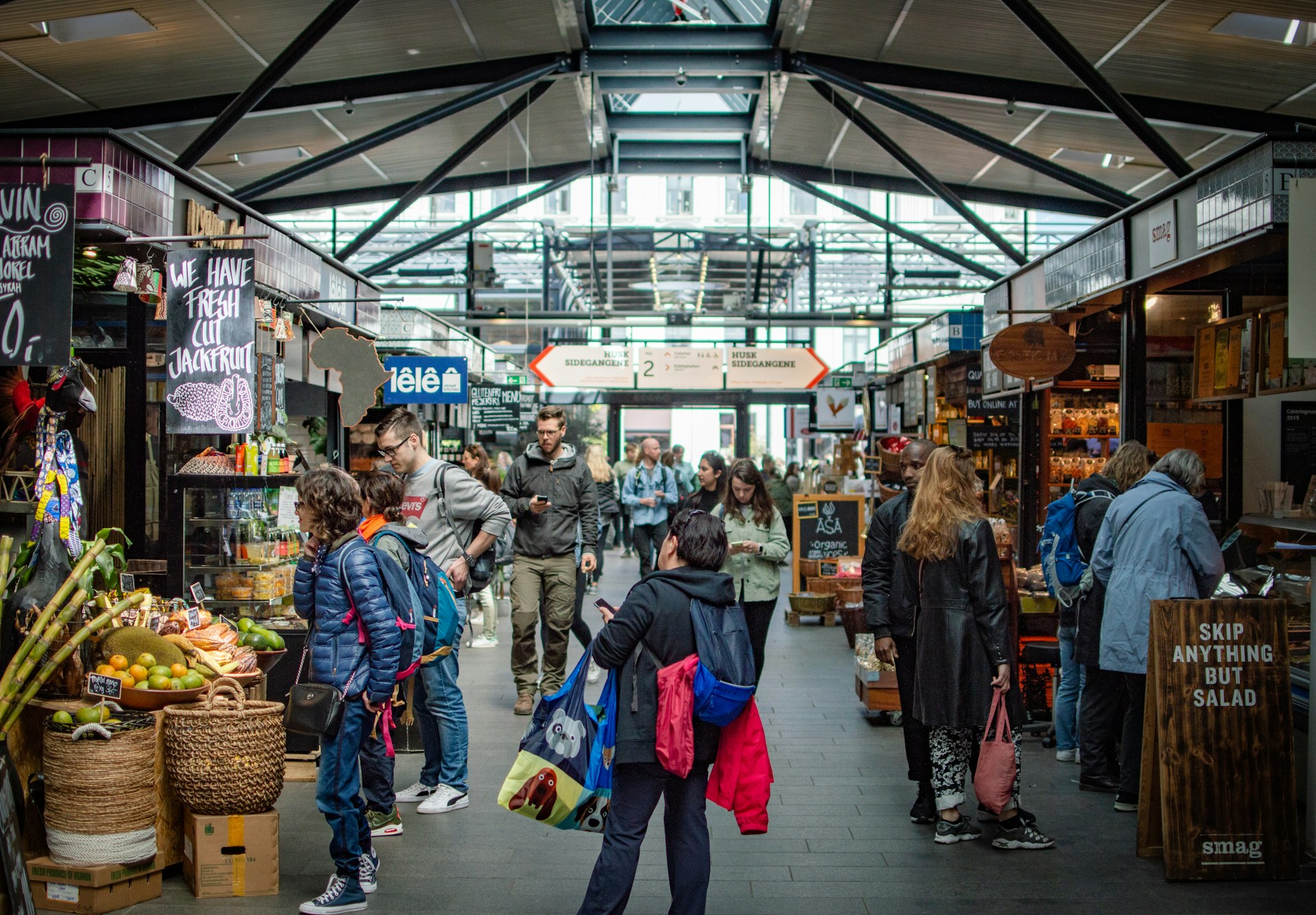 People wander through a covered food market in Copenhagen. 