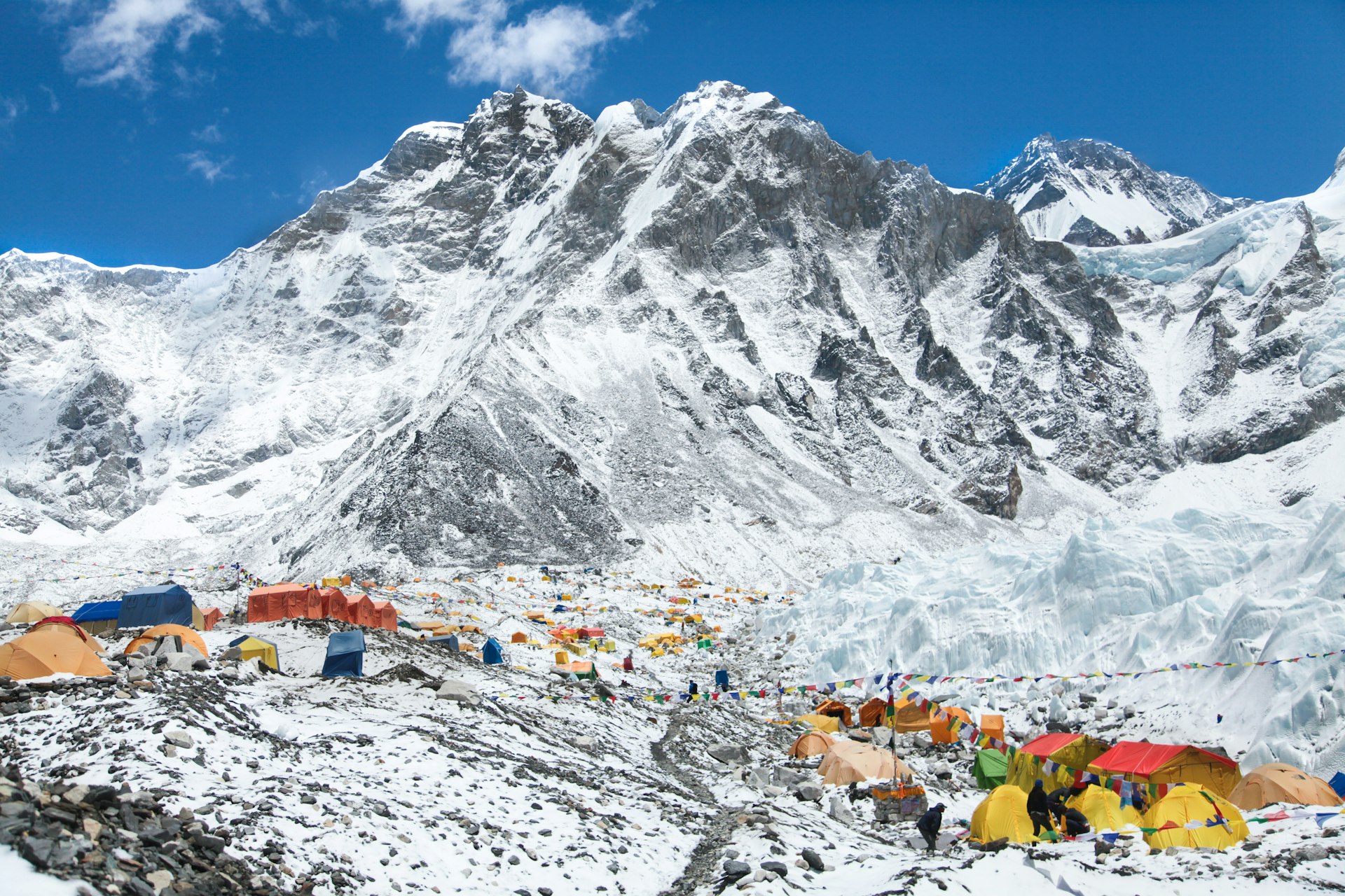 Bright yellow tents in Mount Everest base camp, backed by the Khumbu glacier and snowy mountains. 