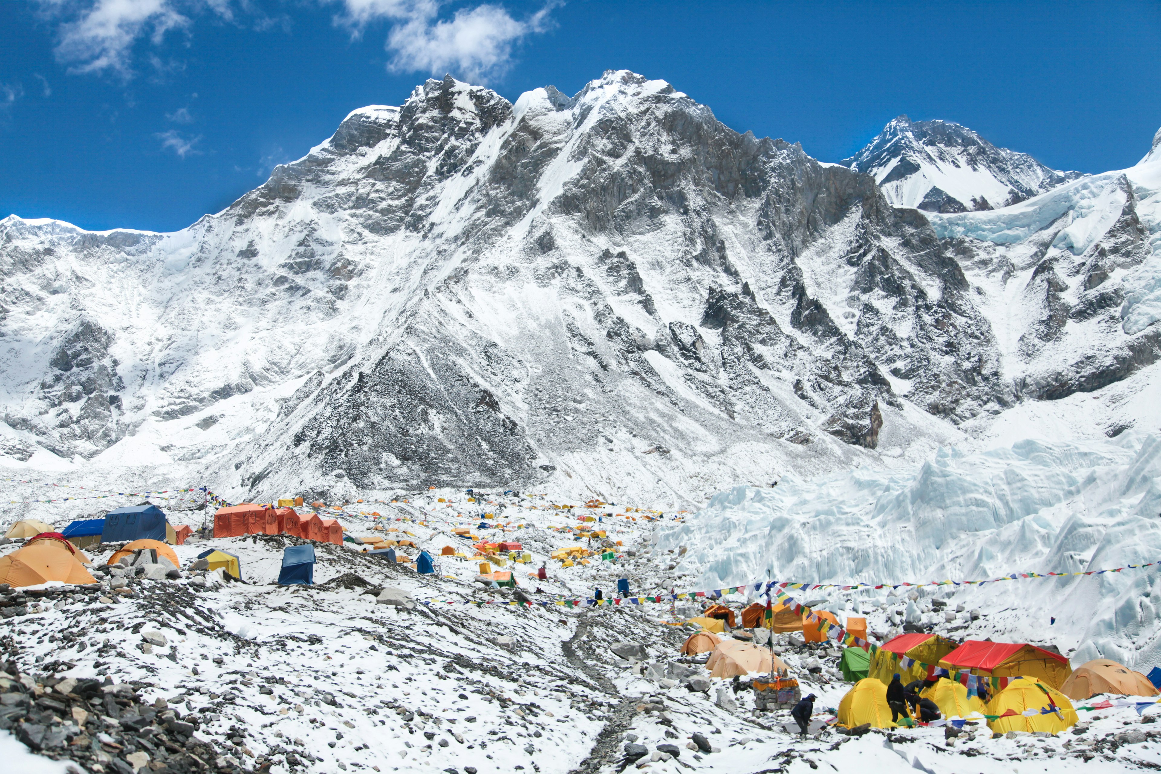 Bright yellow tents in Mount Everest base camp, backed by the Khumbu glacier and snowy mountains.