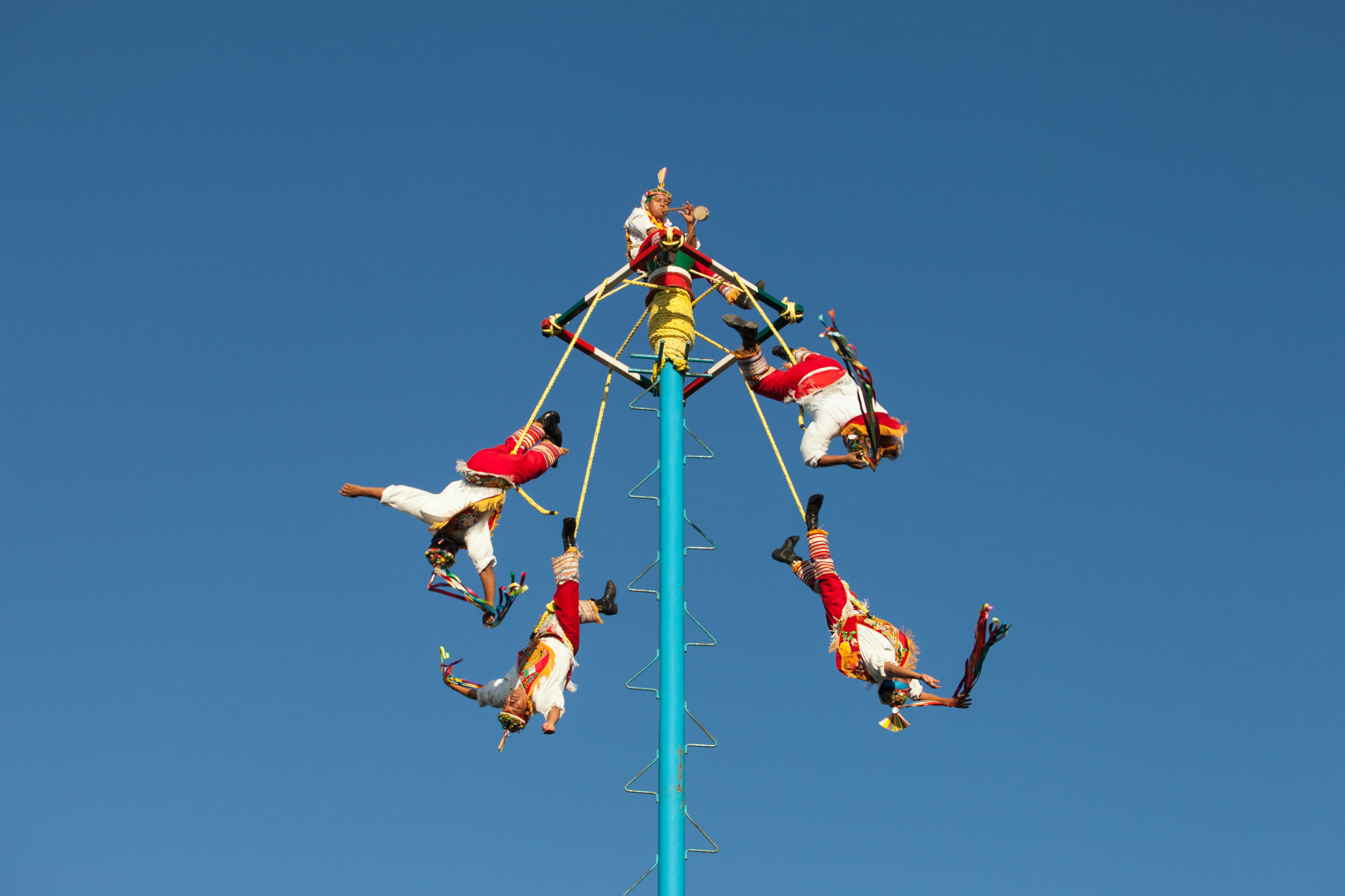 Five flying acrobats enacting a traditional ritual