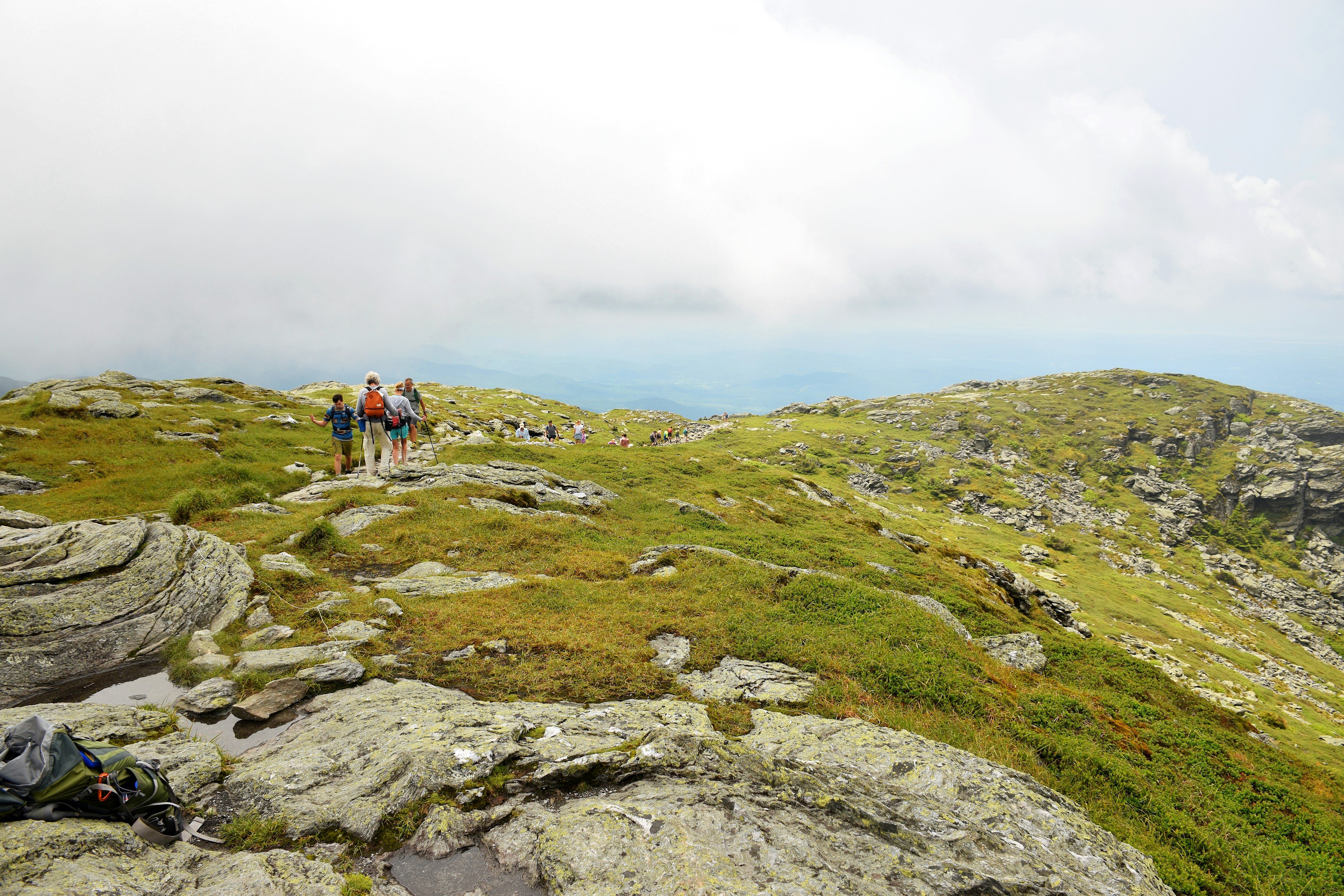 Hikers enjoying the panoramic views from the top of a rocky trail