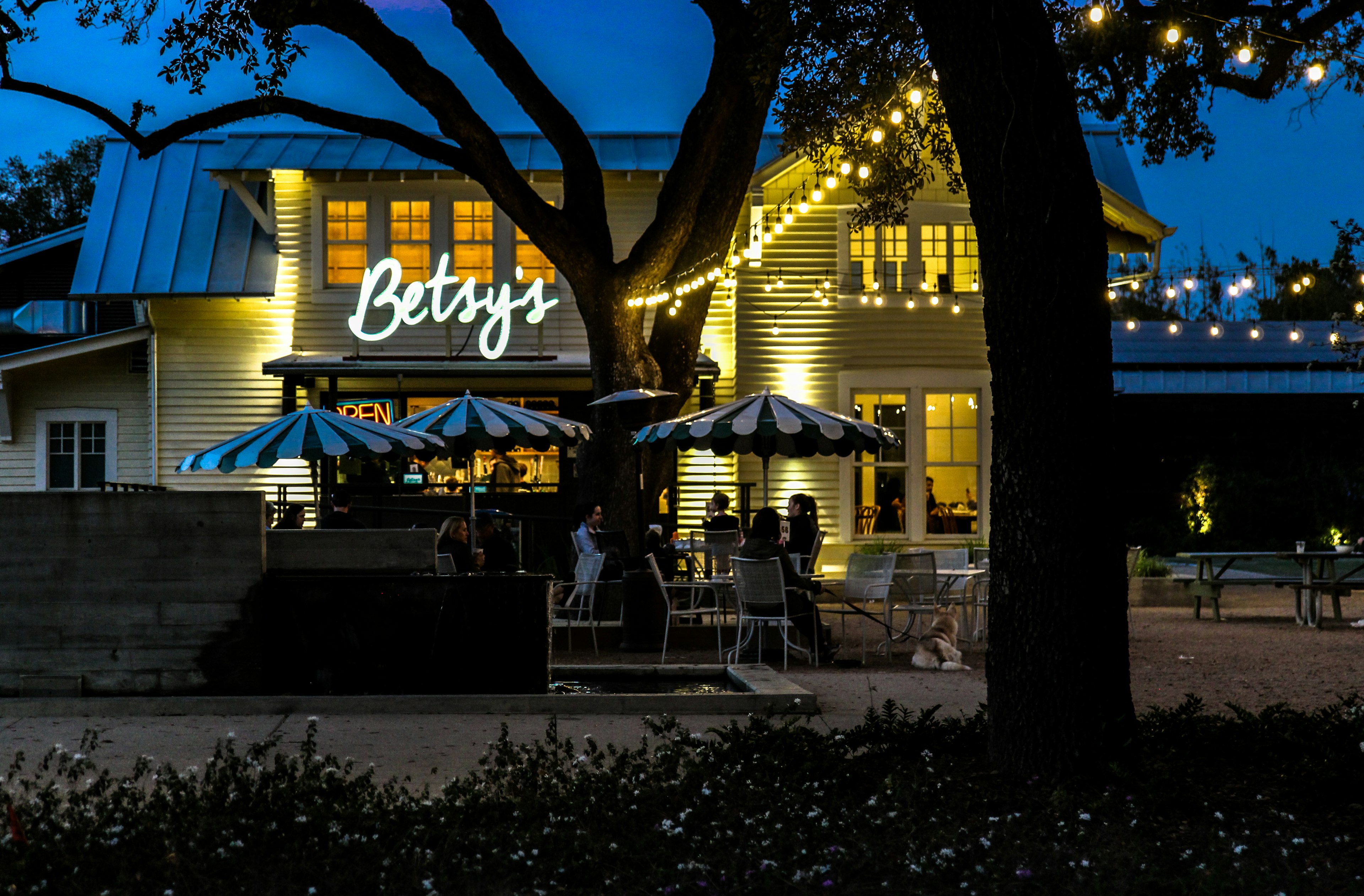 A sign above a restaurant at dusk reading