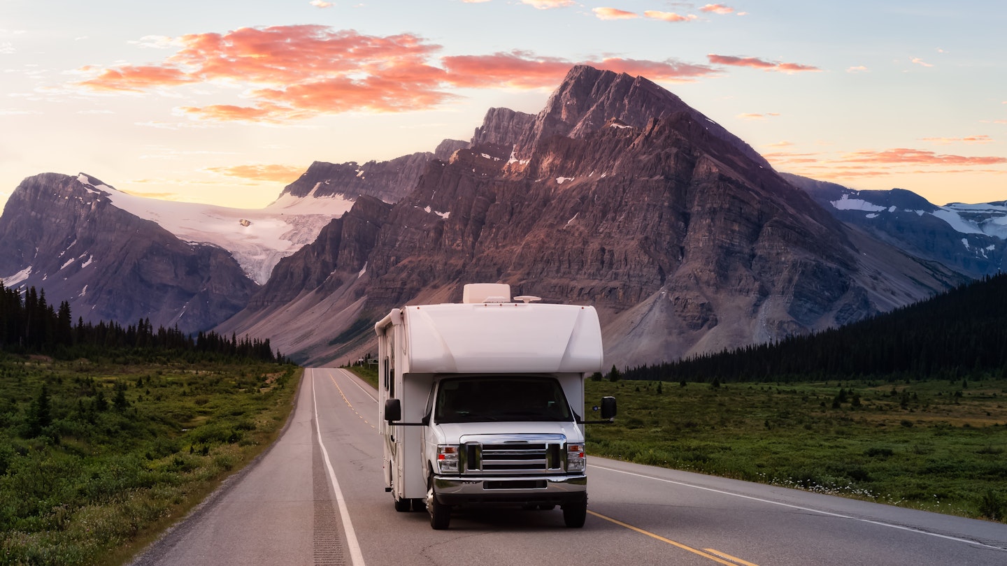 Scenic road in the Canadian Rockies during a vibrant sunny summer sunrise. White RV Driving on route. Taken in Icefields Parkway, Banff National Park, Alberta, Canada., License Type: media_digital, Download Time: 2024-08-21T21:06:05.000Z, User: bfreeman_lonelyplanet, Editorial: false, purchase_order: 65050, job: Online Editorial, client: Best places to RV , other: Bailey Freeman