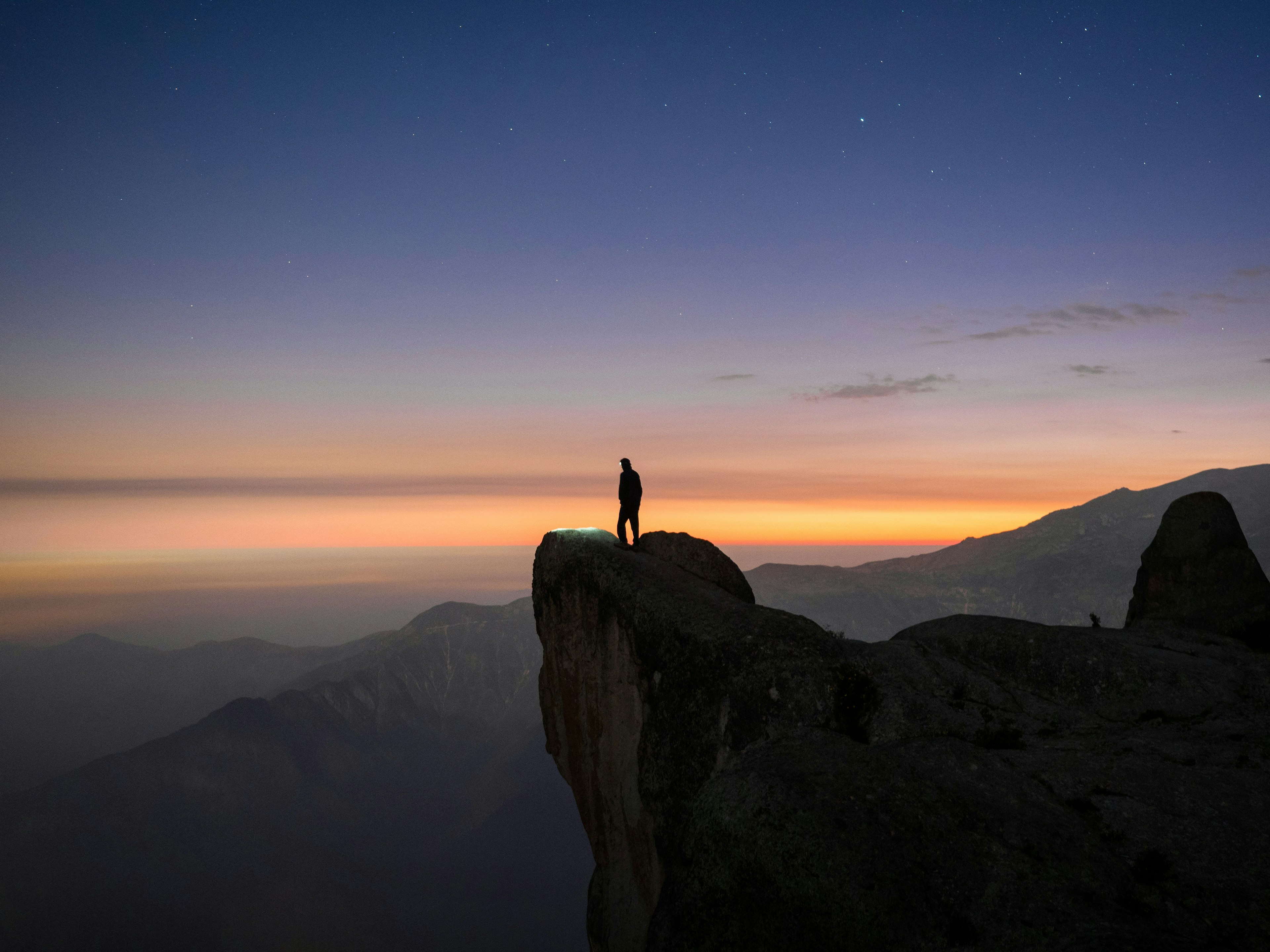 A solitary figure, in the early evening light, looks over a panoramic view from Marcahuasi, a plateau in the Andes Mountains