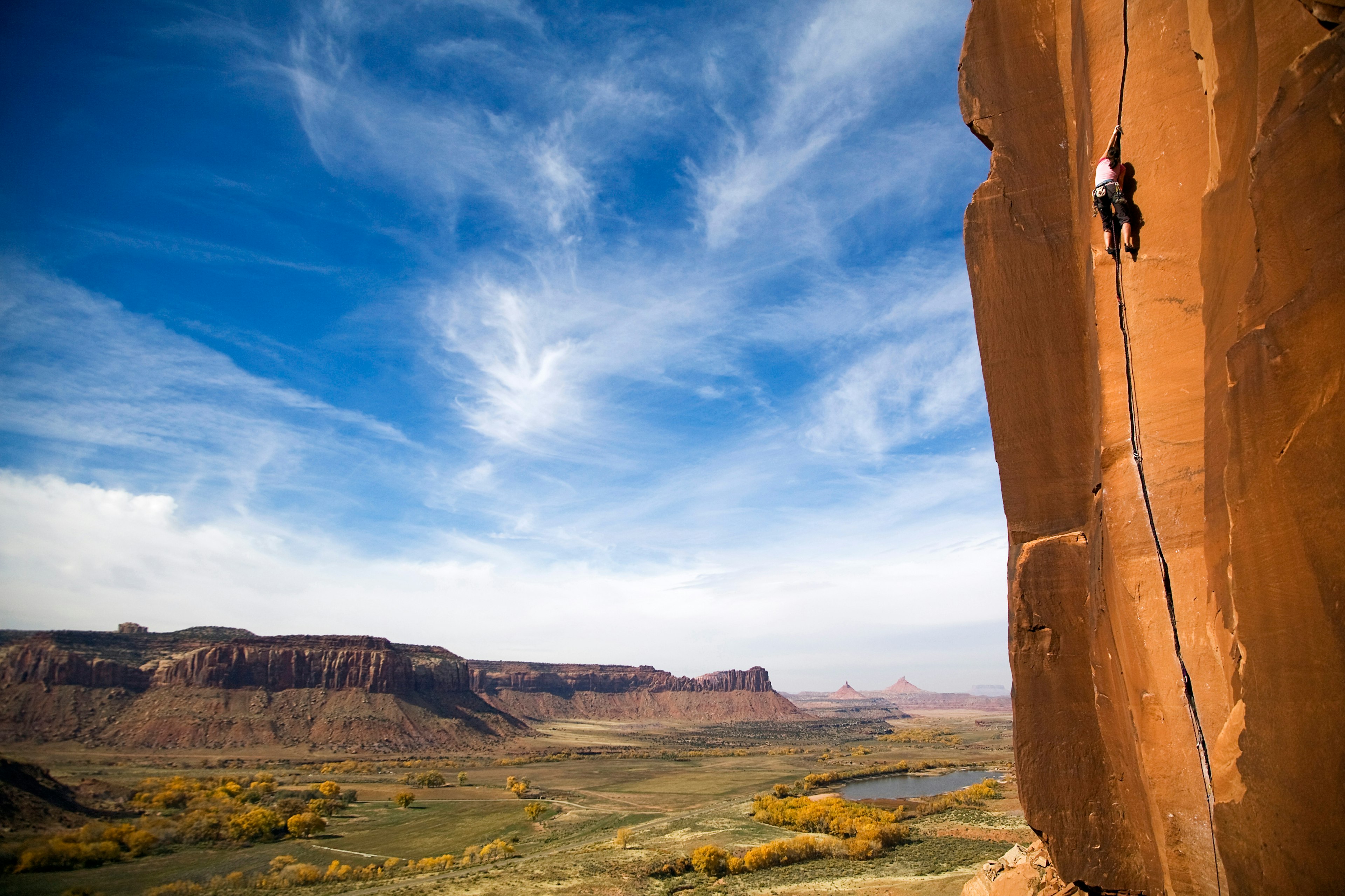 A female climber ascending a rockface at Indian Creek