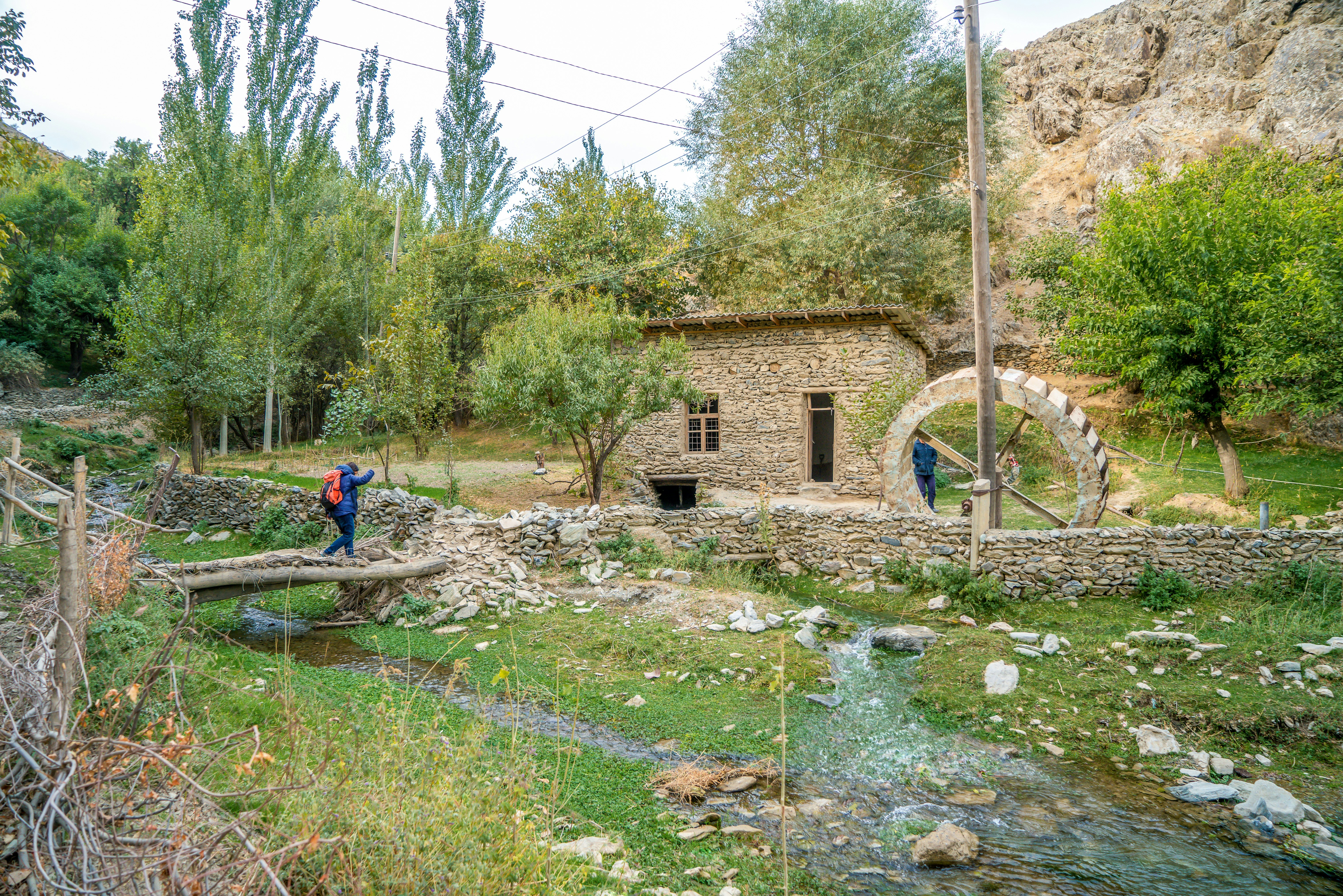 Uzbekistan, a women is hiking in the Nuratau mountains near the Asrof next a watermill,