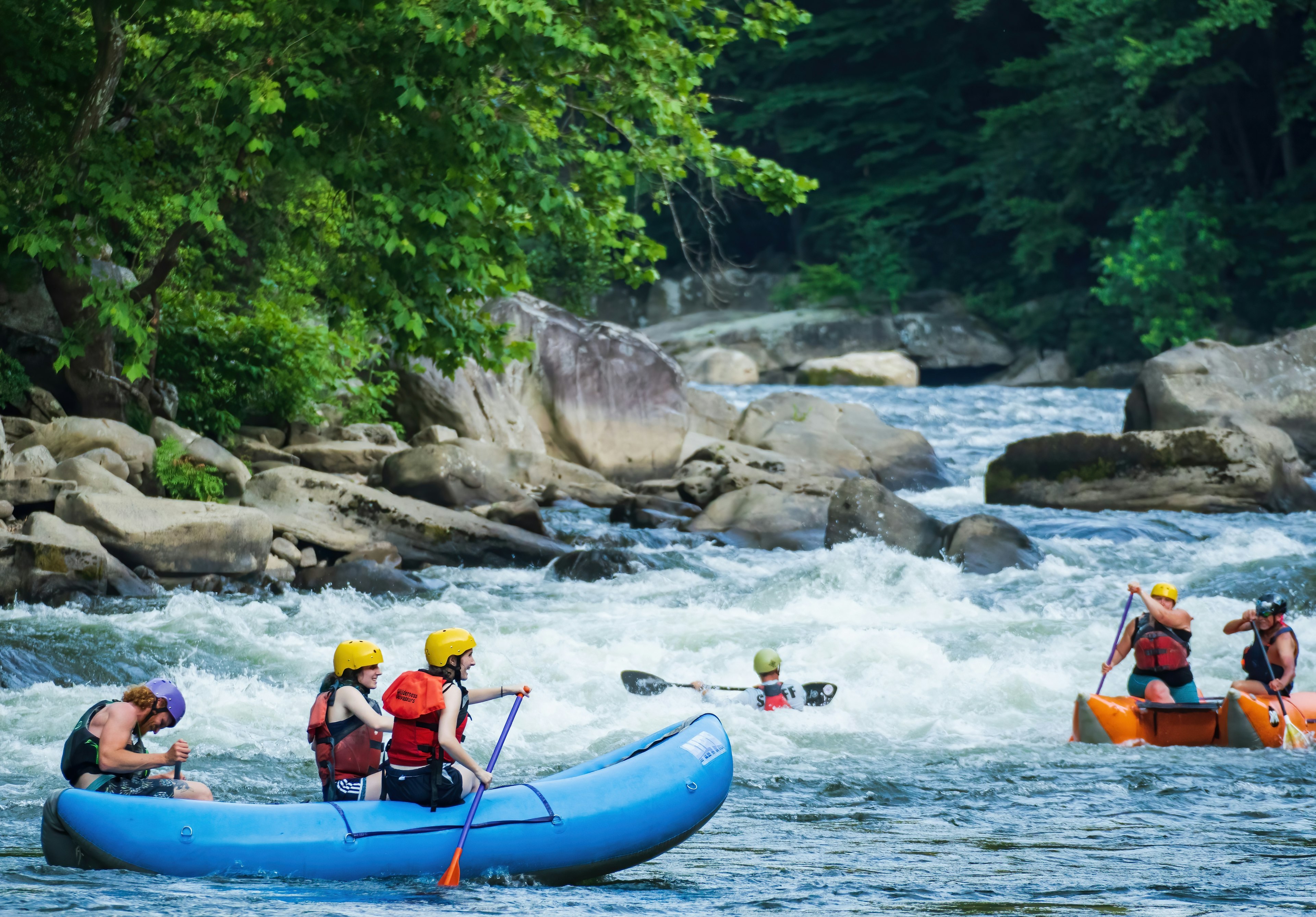 People in three rafts paddle in the white-water rapids along the Youghiogheny River in Pennsylvania’s Ohiopyle State Park