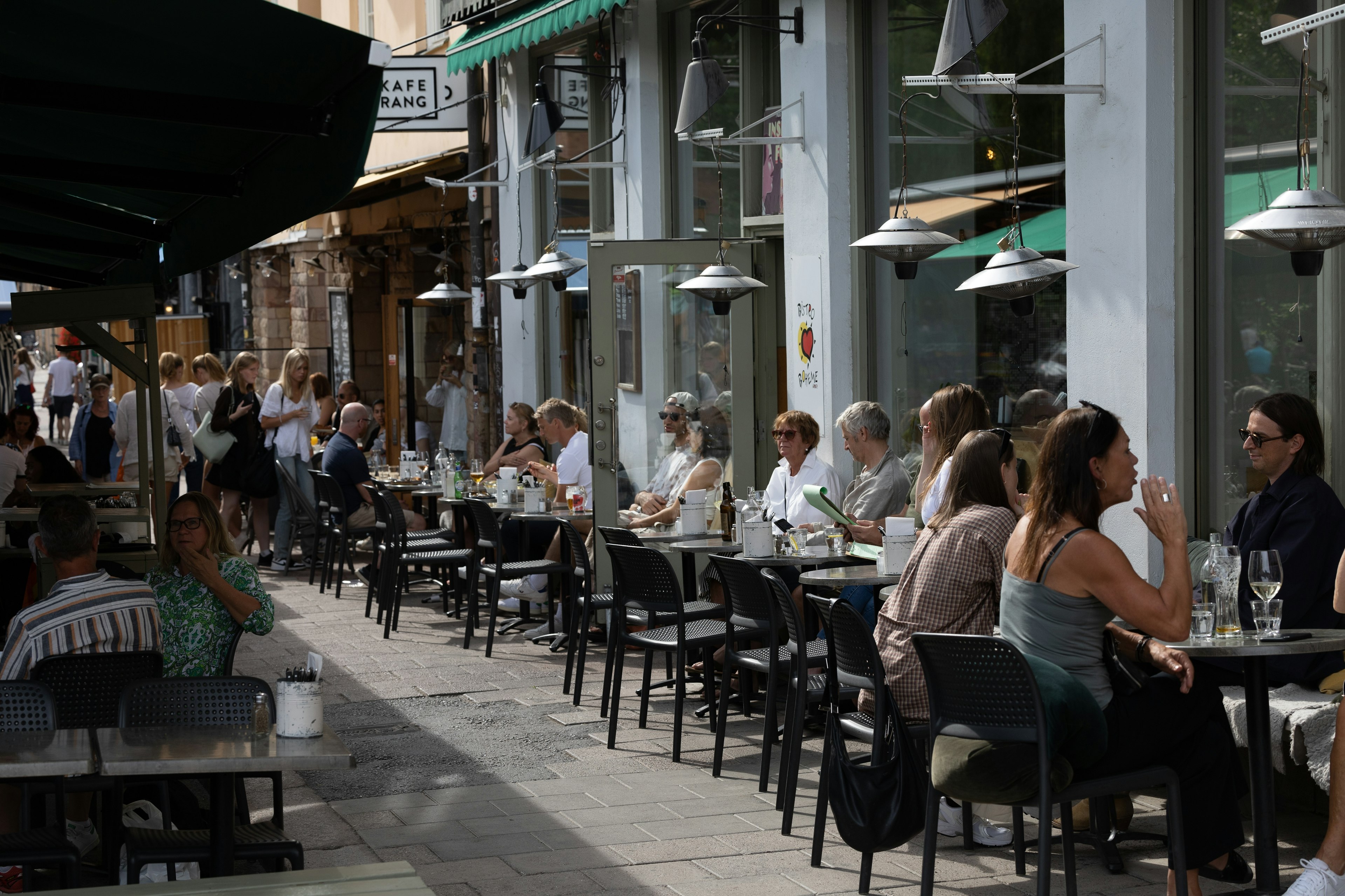 People sitting at an outdoor restaurant on Nytorget on Södermalm, a hip and fancy district in Stockholm, Swedent