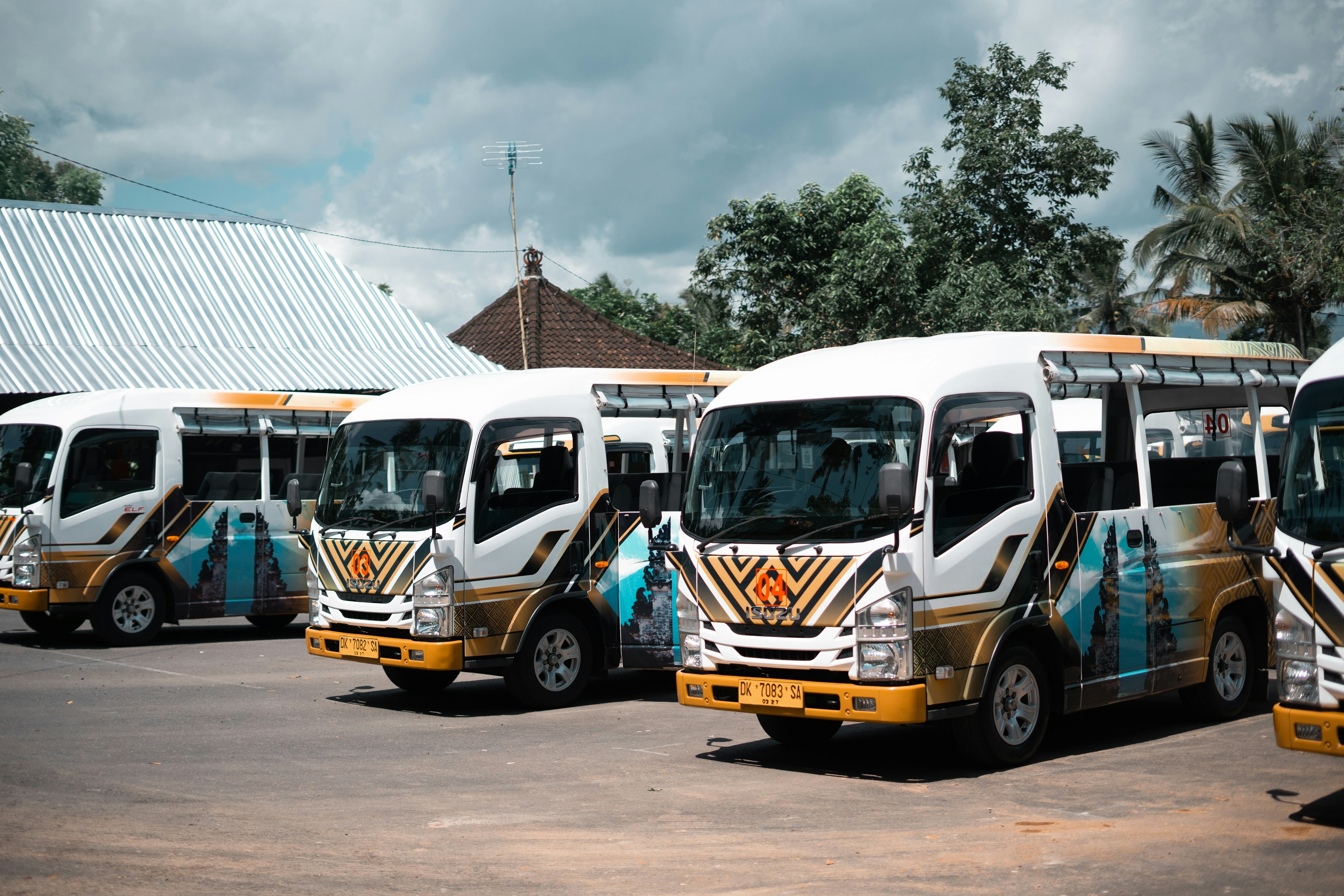 A row of minibuses stand at a bus depot