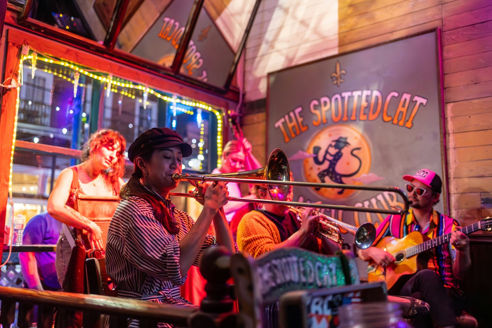 ve band playing music a local bar in NOLA during the spring at night. the high energy or the crowd spread across the scene 